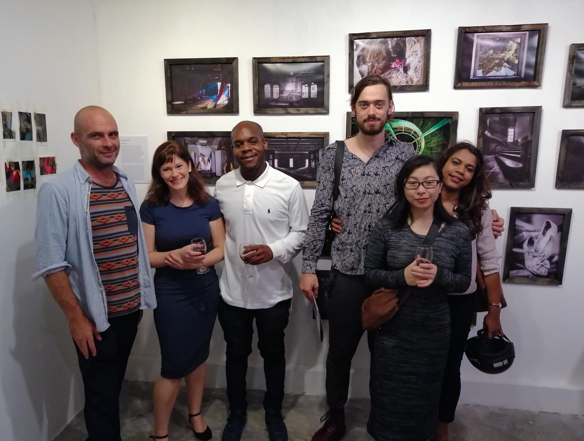 The artist and fine art photographer Tobias Ahlbrecht with the Model Zarah Nguyen and several friends in front of Ahlbrecht's Decay printed photographs.