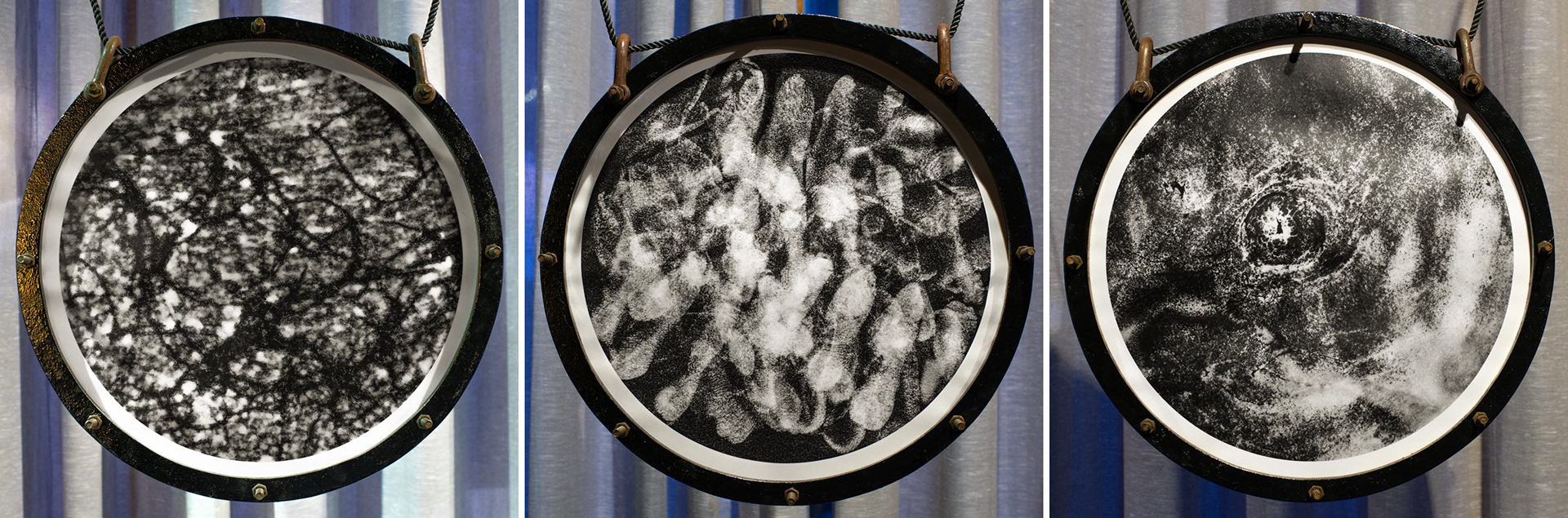 Detailed image of the three handmade photographs in circular wodden black frames by Tobias Ahlbrecht from his 'One' series as shown in Saigon, Vietnam.