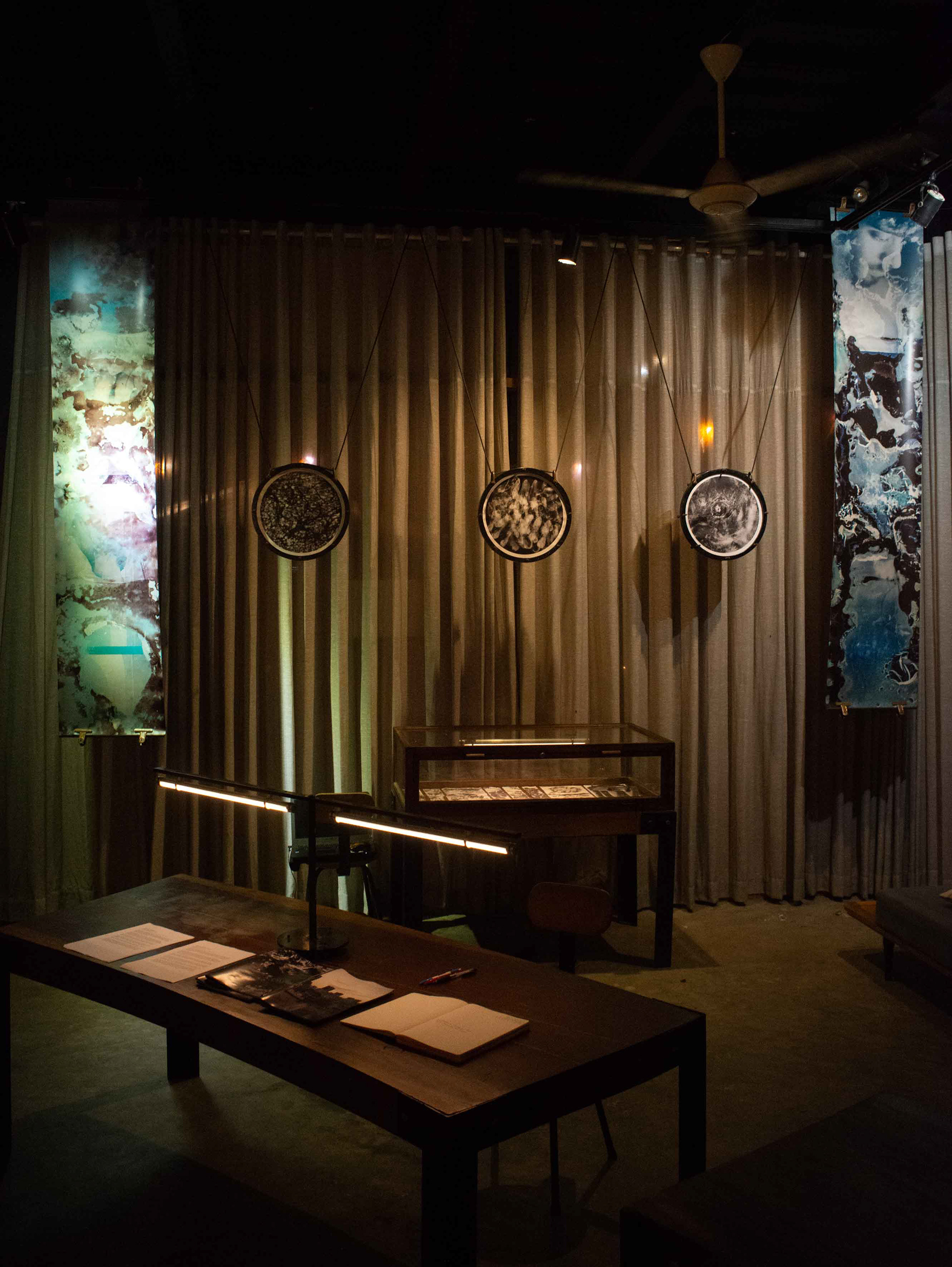 Several handmade photographs in circular wooden frames by Tobias Ahlbrecht from his 'One' Series at the Schiller River Club in Saigon Vietnam.