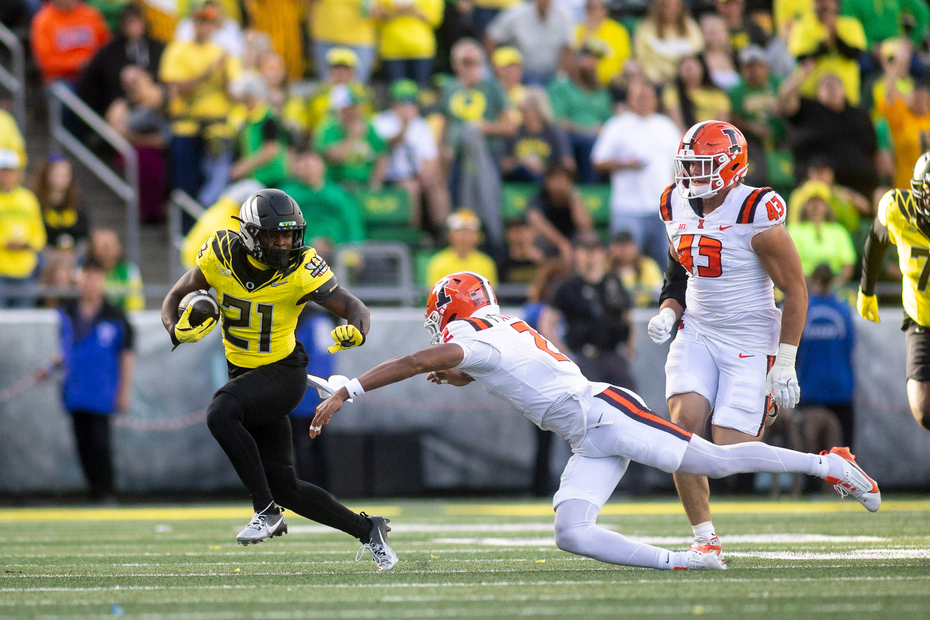 Oregon running back Da'Jaun Riggs (21) runs the ball before being tackled by Illinois defensive back Saboor Karriem during the game on Oct. 26, 2024. The No. 1 Oregon Ducks beat the No. 20 Illinois Fighting Illini 38-9. | Shot for Emerald Media Group | 1/8000 f/2.8 ISO800