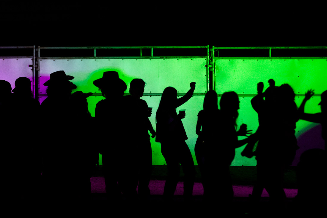 People dance after the events and fireworks at the rodeo on July 3, 2024. The Eugene Pro Rodeo kicked off its first day with the theme of "Tough Enough to Wear Pink," in support of cancer awareness. | Shot for Emerald Media Group | 1/125 f/2.8 ISO6400