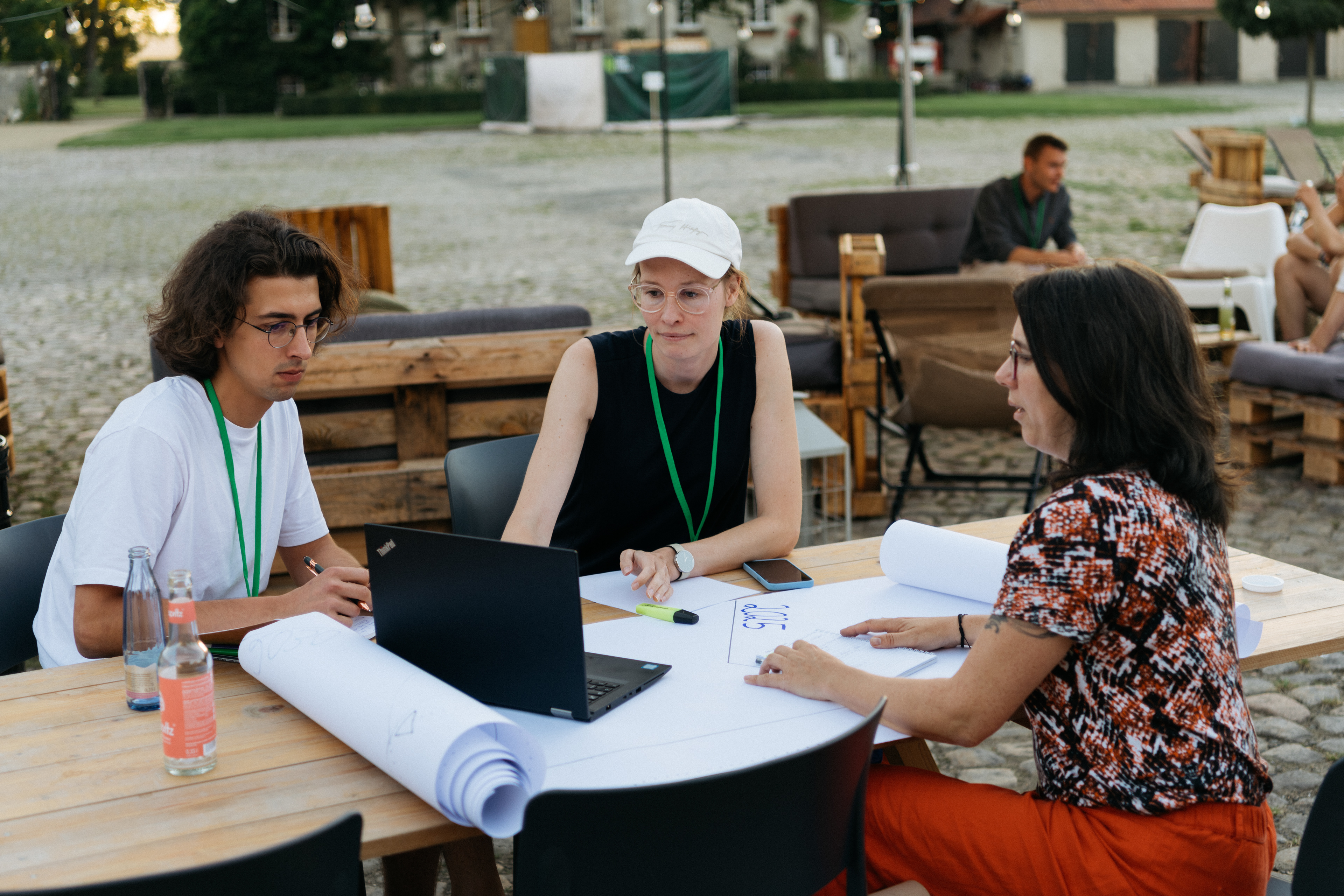 Drei Teilnehmerinnen arbeiten gemeinsam an einem Tisch während einer Session des Farm Food Climate Festivals.