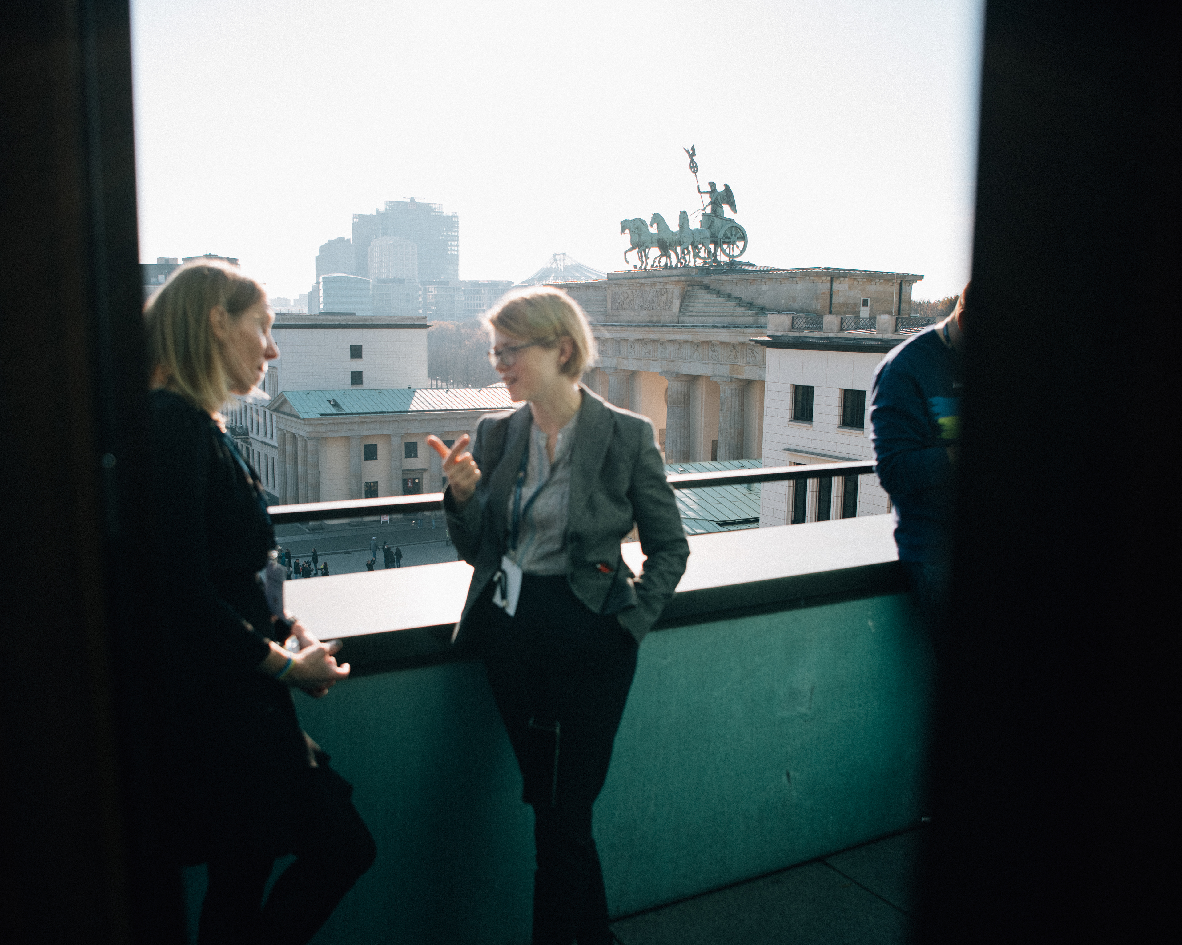 Zwei Teilnehmerinnen im Gespräch auf einer Terrasse mit Blick über Berlin.