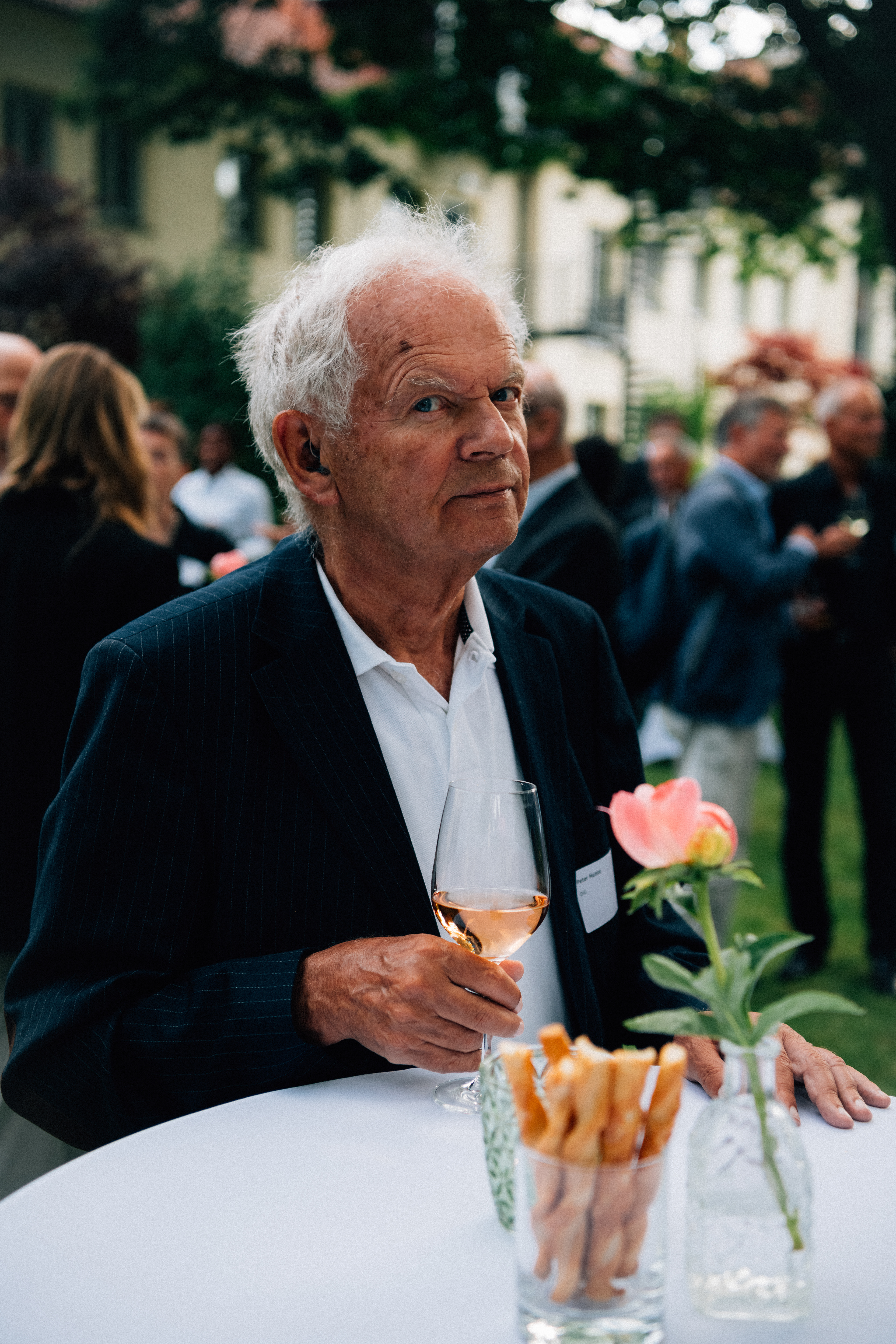 Gast mit Getränk an einem Stehtisch während des Empfangs der Stiftung Zukunft Berlin.