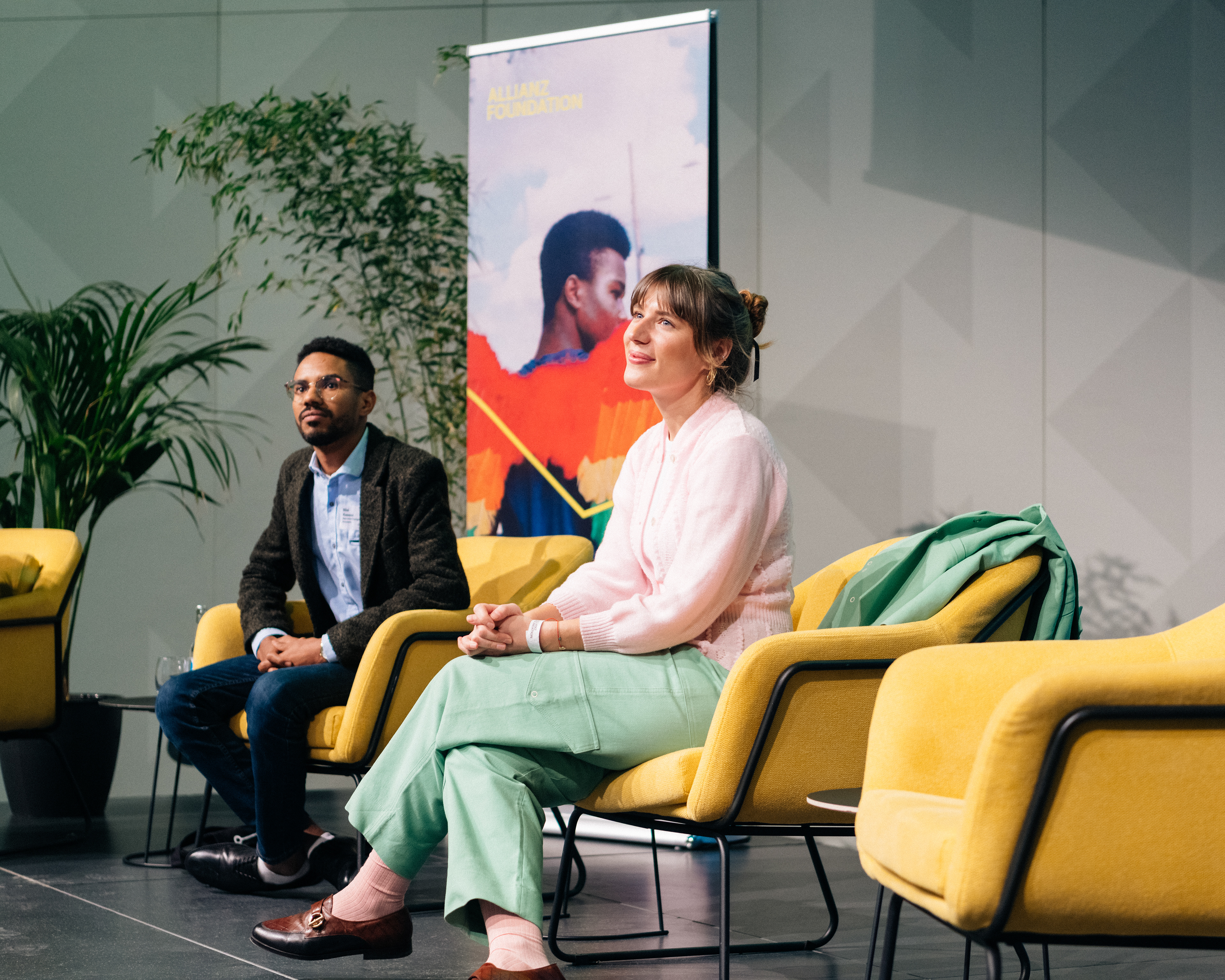 Zwei Speaker im Gespräch auf der Bühne beim Summit „Toward Just Futures“ der Allianz Foundation.