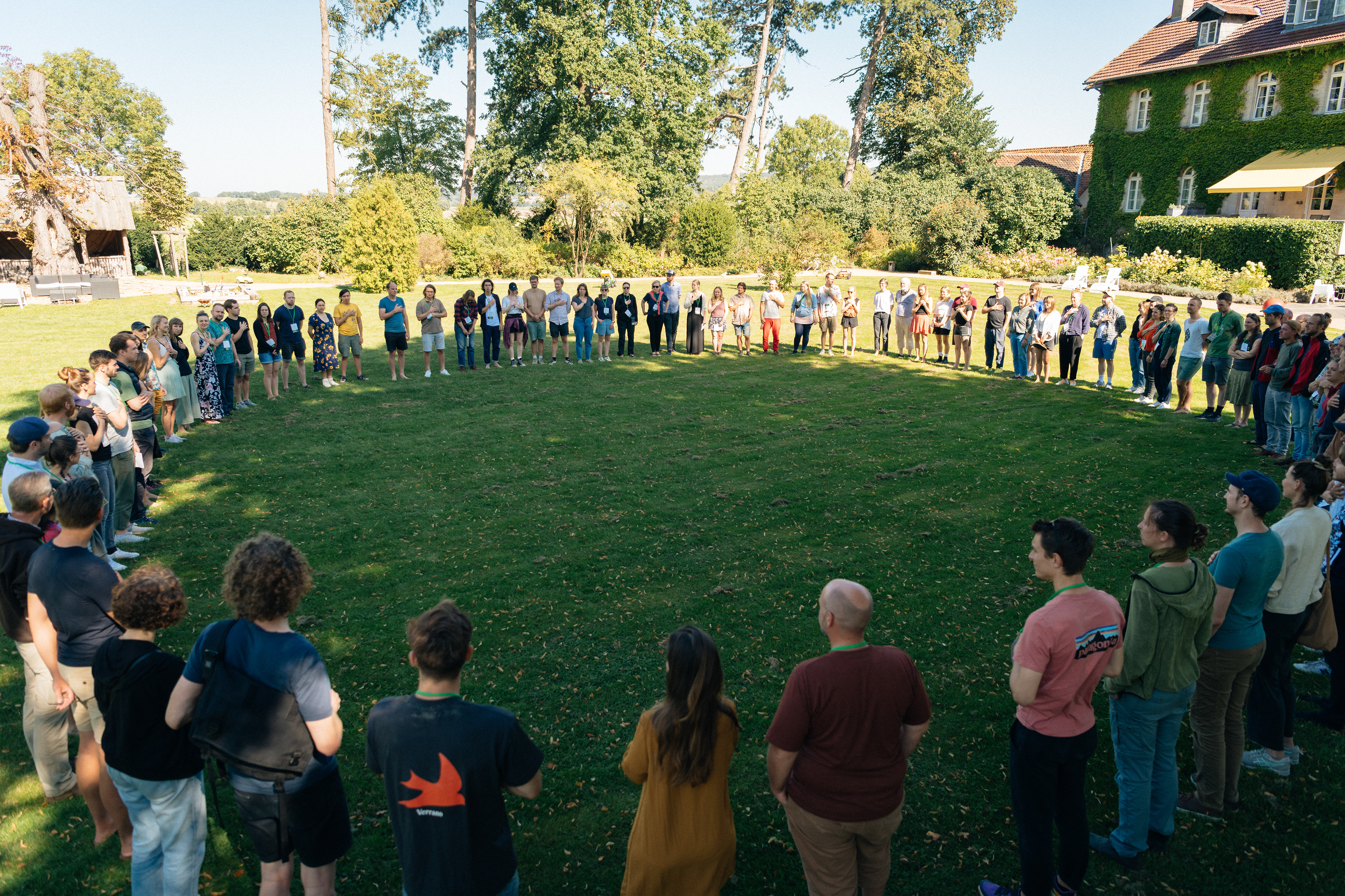 Großer Teilnehmendenkreis auf einer Wiese beim Farm Food Climate Festival.