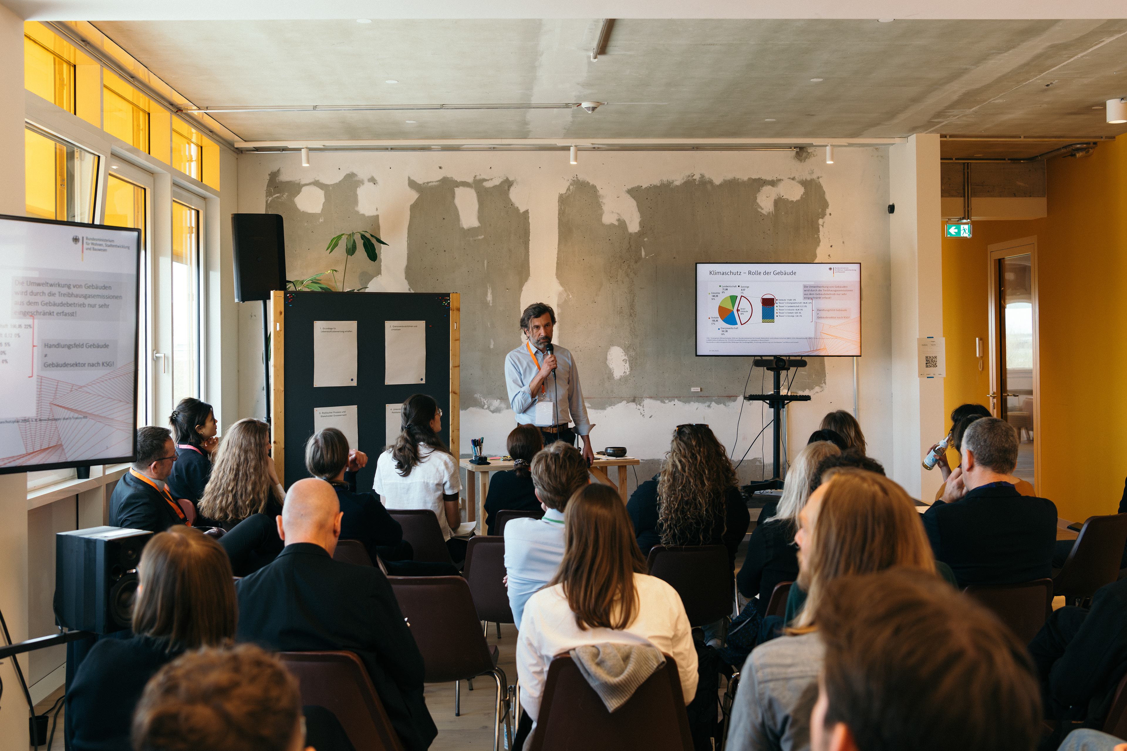 Präsentation vor sitzenden Teilnehmenden beim Bauwende Allianz Policy Lab in Berlin.