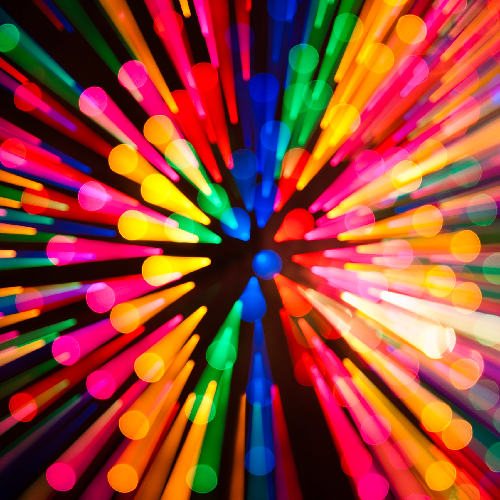 An abstract image created by zooming in on a collection of unfocused Christmas lights during a long exposure.