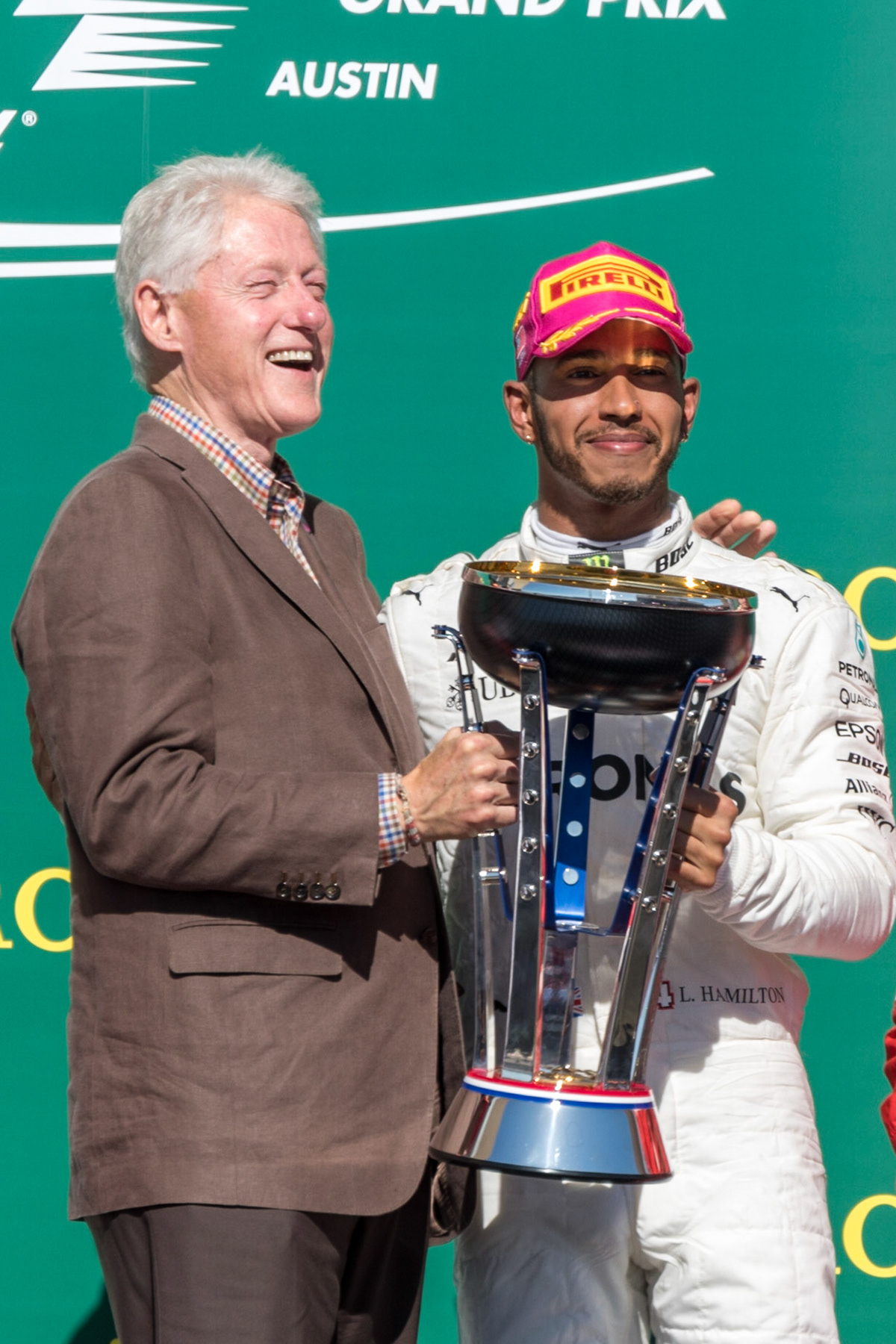 Bill Clinton laughs during an exchange with US Grand Prix winner Lewis Hamilton on the podium at Circuit of the Americas on October 22nd, 2017.