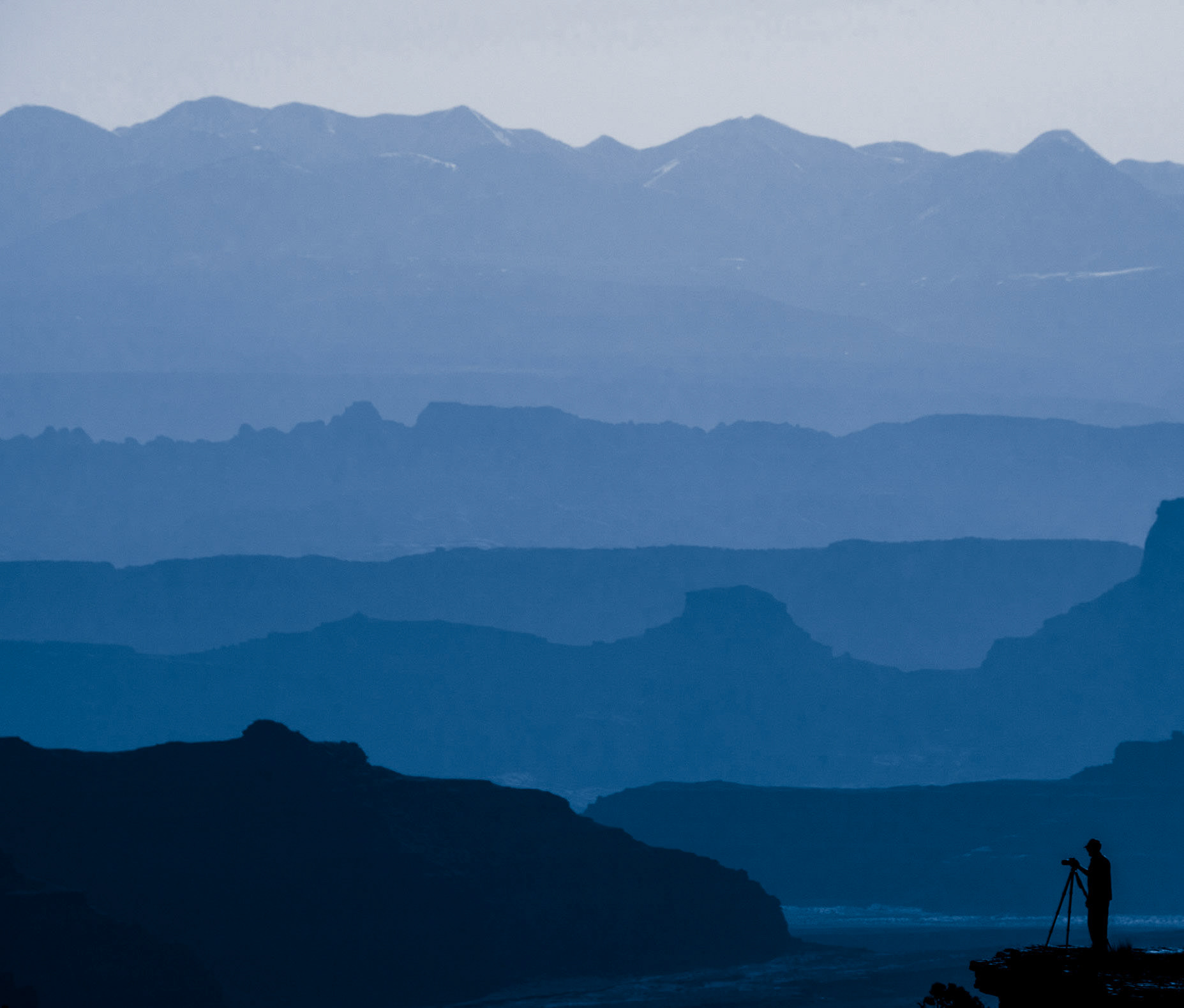 A lone photographer sets up a shot at Shafer Canyon in Canyonlands National Park, Utah.