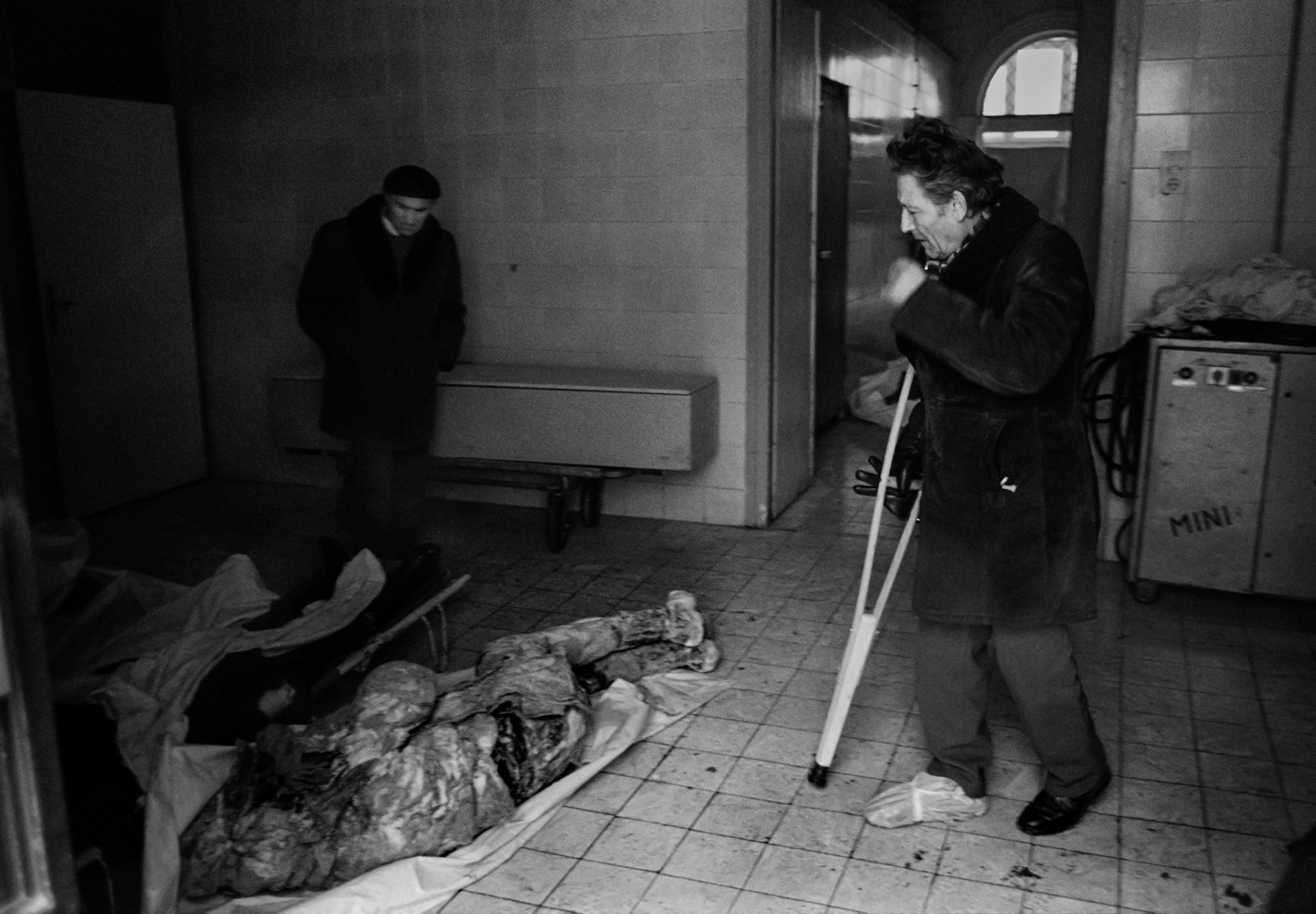 A man looks for a missing friend or relative among newly arrived corpses in the besieged Bosnian capital Sarajevo morgue on December 15, 1992.