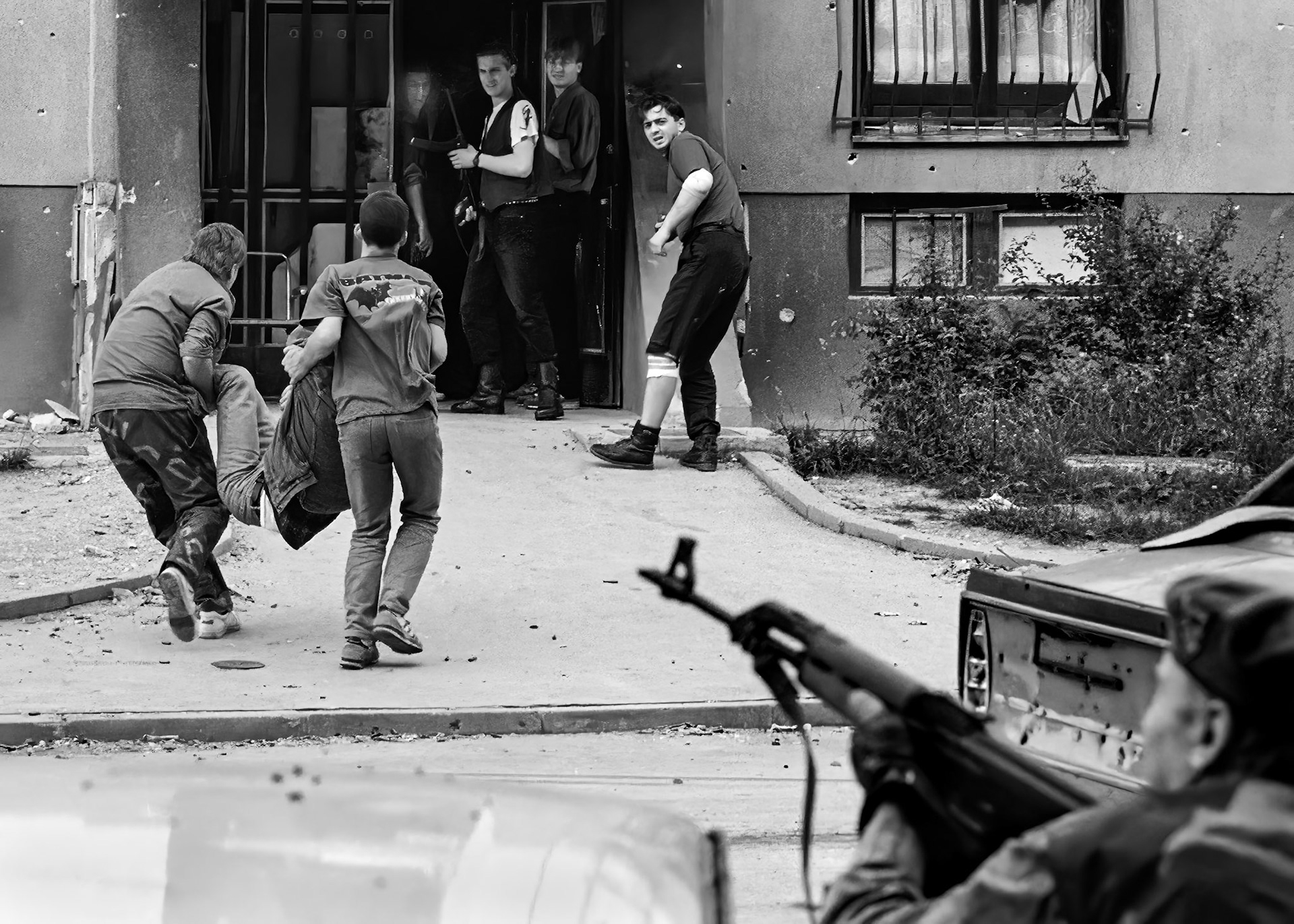 A wounded Bosnian ambulance driver is carried into a building in Sarajevo's Dobrinja suburb by Bosnian government fighters on June 24, 1992. He was driving one of three ambulances that came under fire from Bosnian Serb positions.