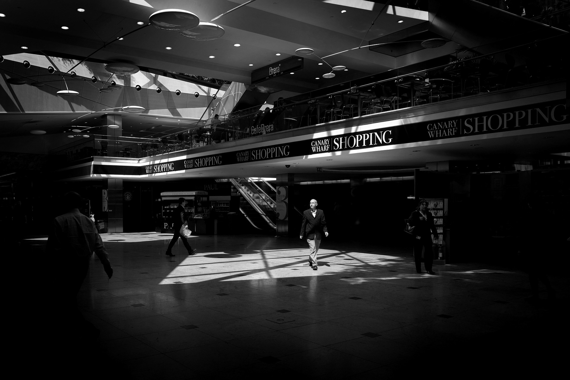 Man walks through a pool of light at Canary Wharf
