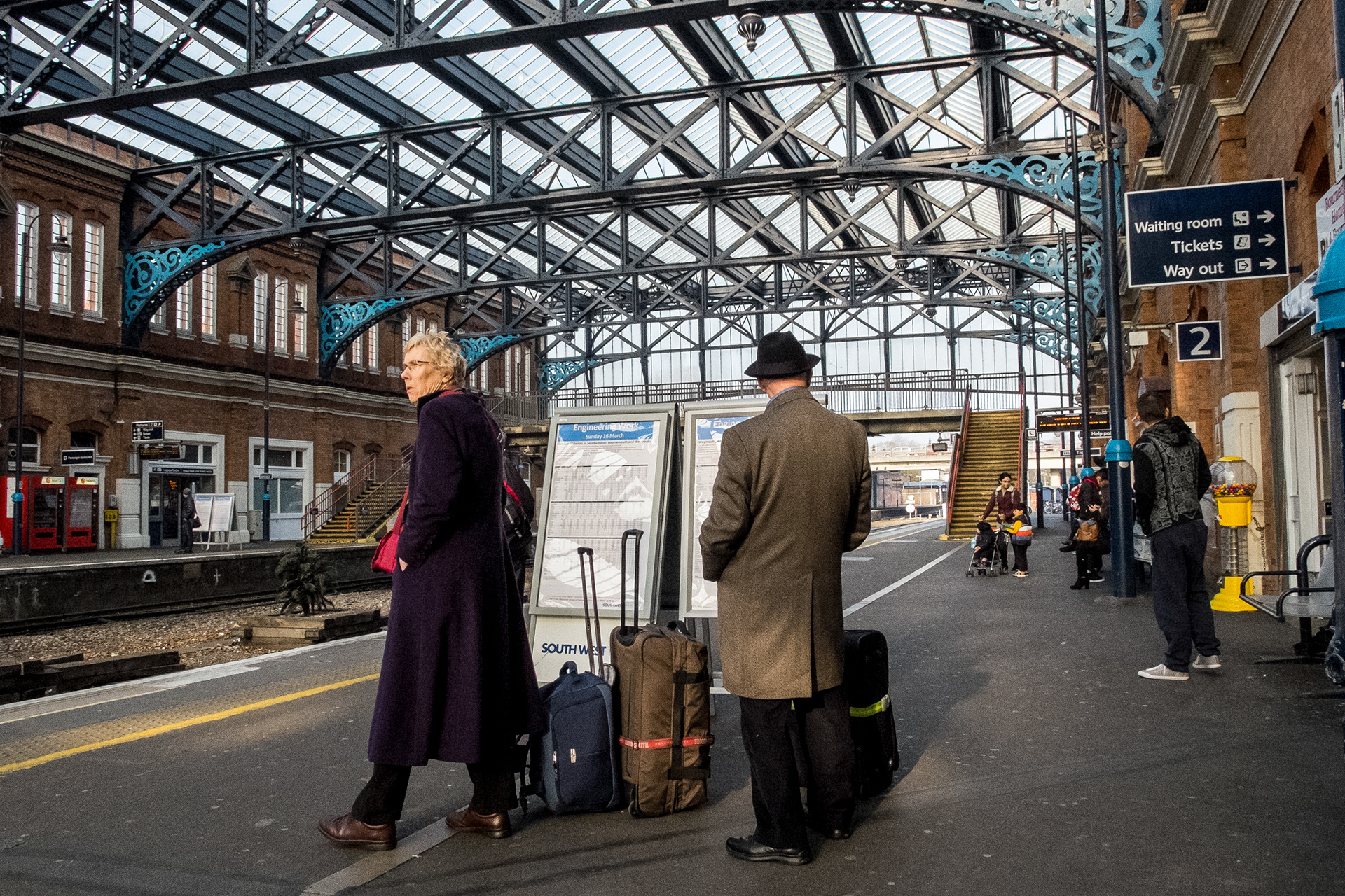 Couple with luggage wait for a train at Bournemouth Station