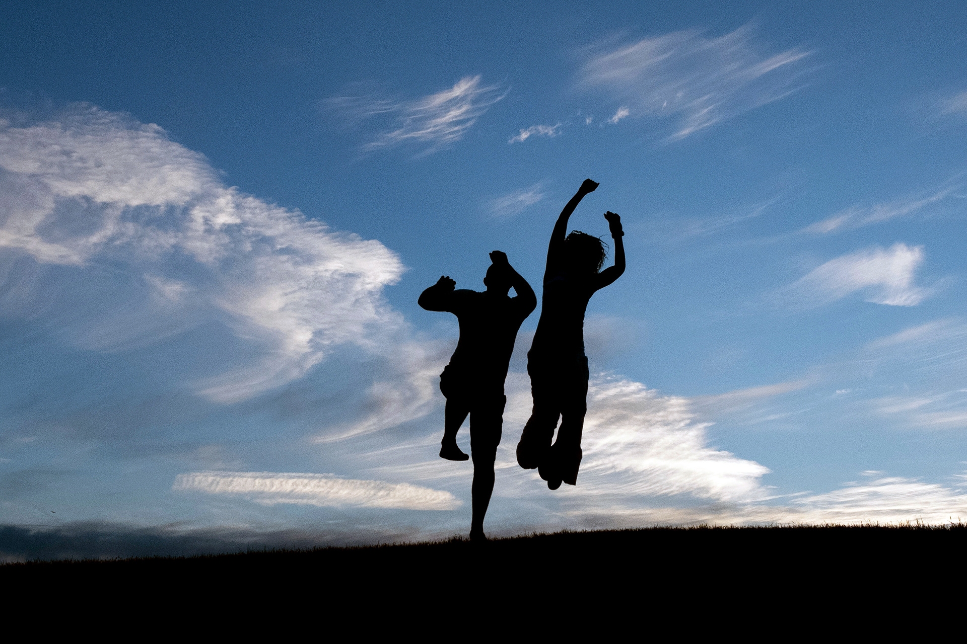 Couple jump together on the cliff tops at Fisherman's Walk in Bournemouth