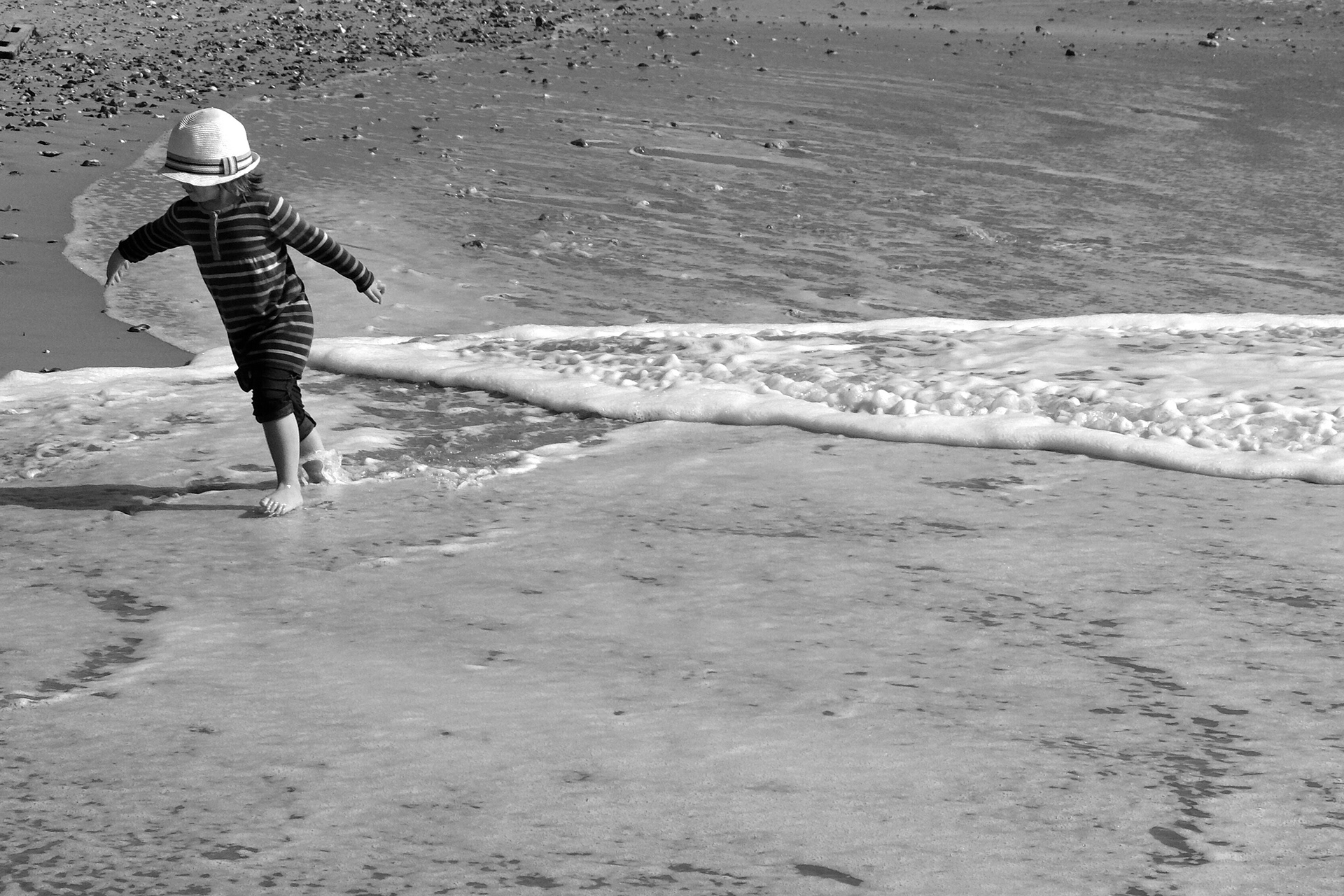 Child playing in the waves at Fisherman's Walk in Bournemouth
