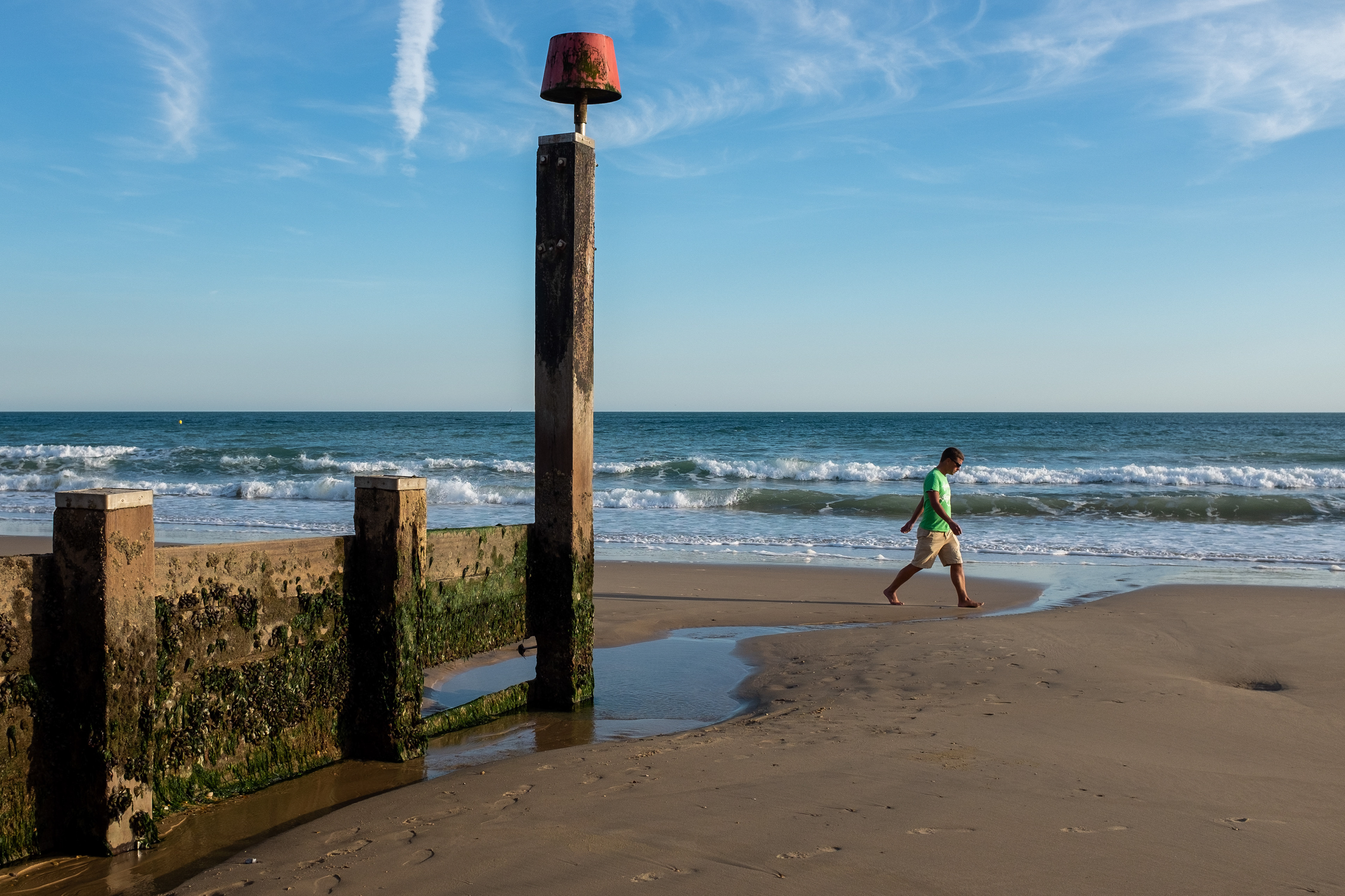 Man walks along the beach at Fisherman's Walk at low tide