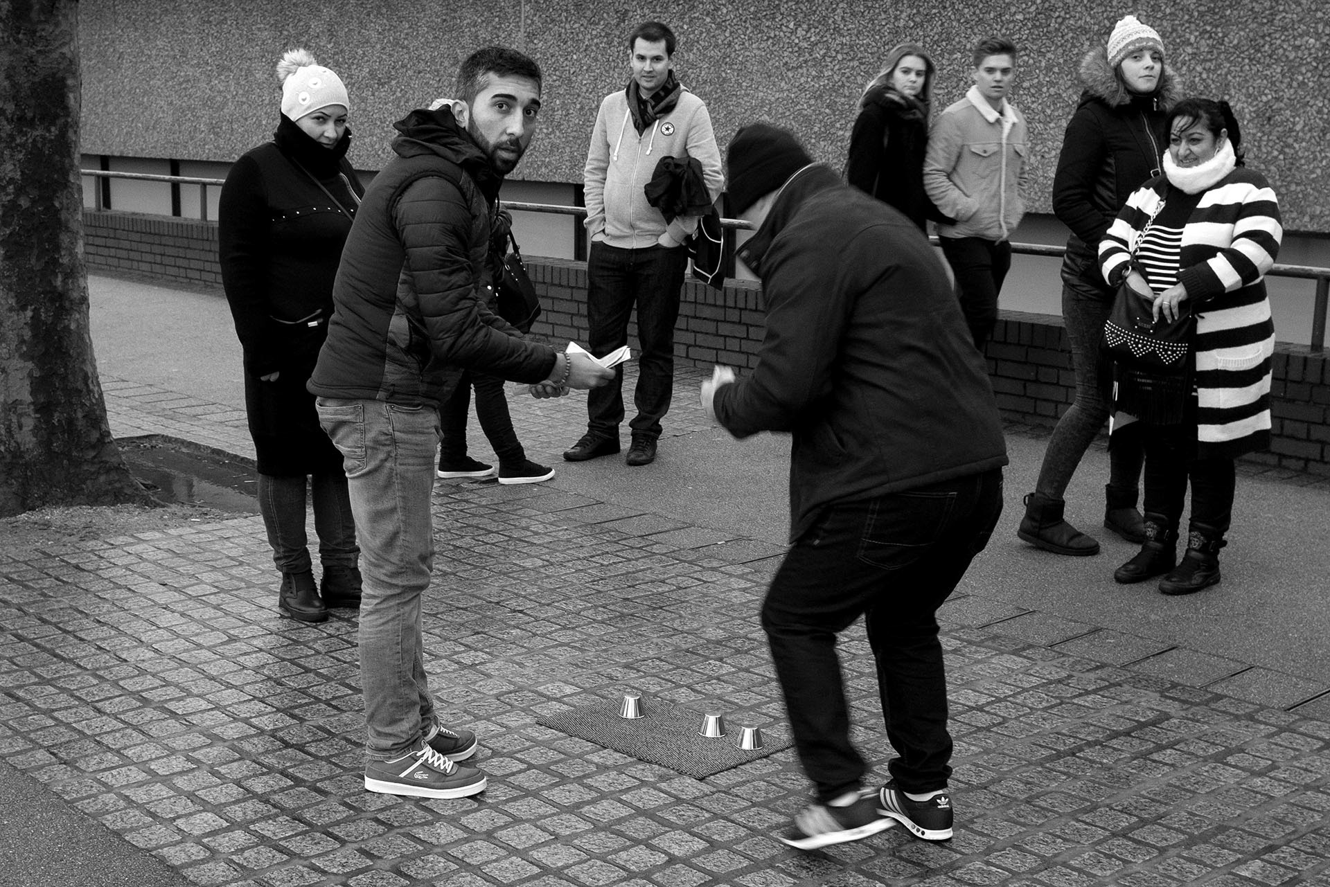 A gang tries to lure tourists into playing the shell game on London's Southbank