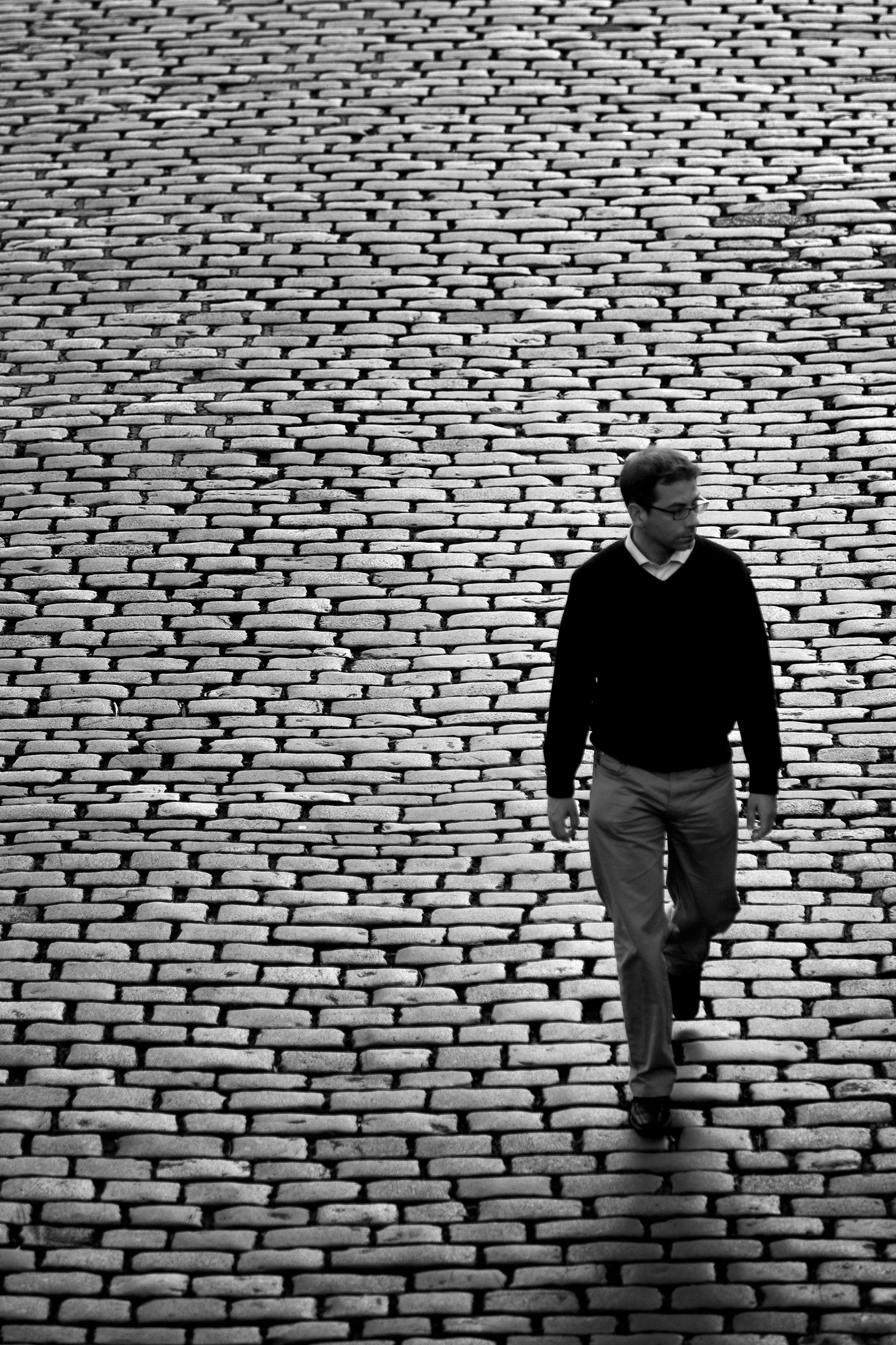 Pedestrian walks along cobbled path outside the Tower of London