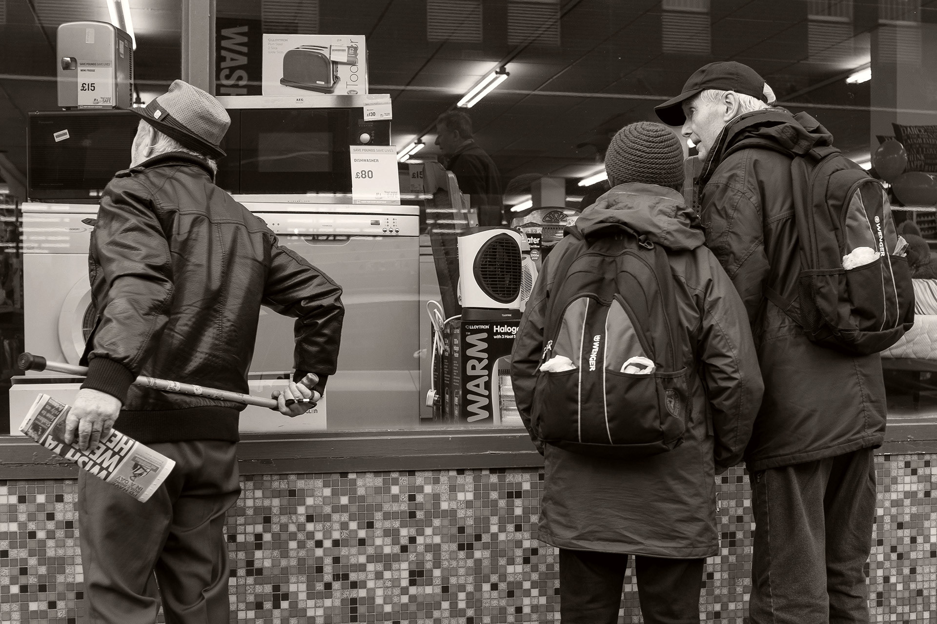 Pensioners window-shopping in a charity shop window