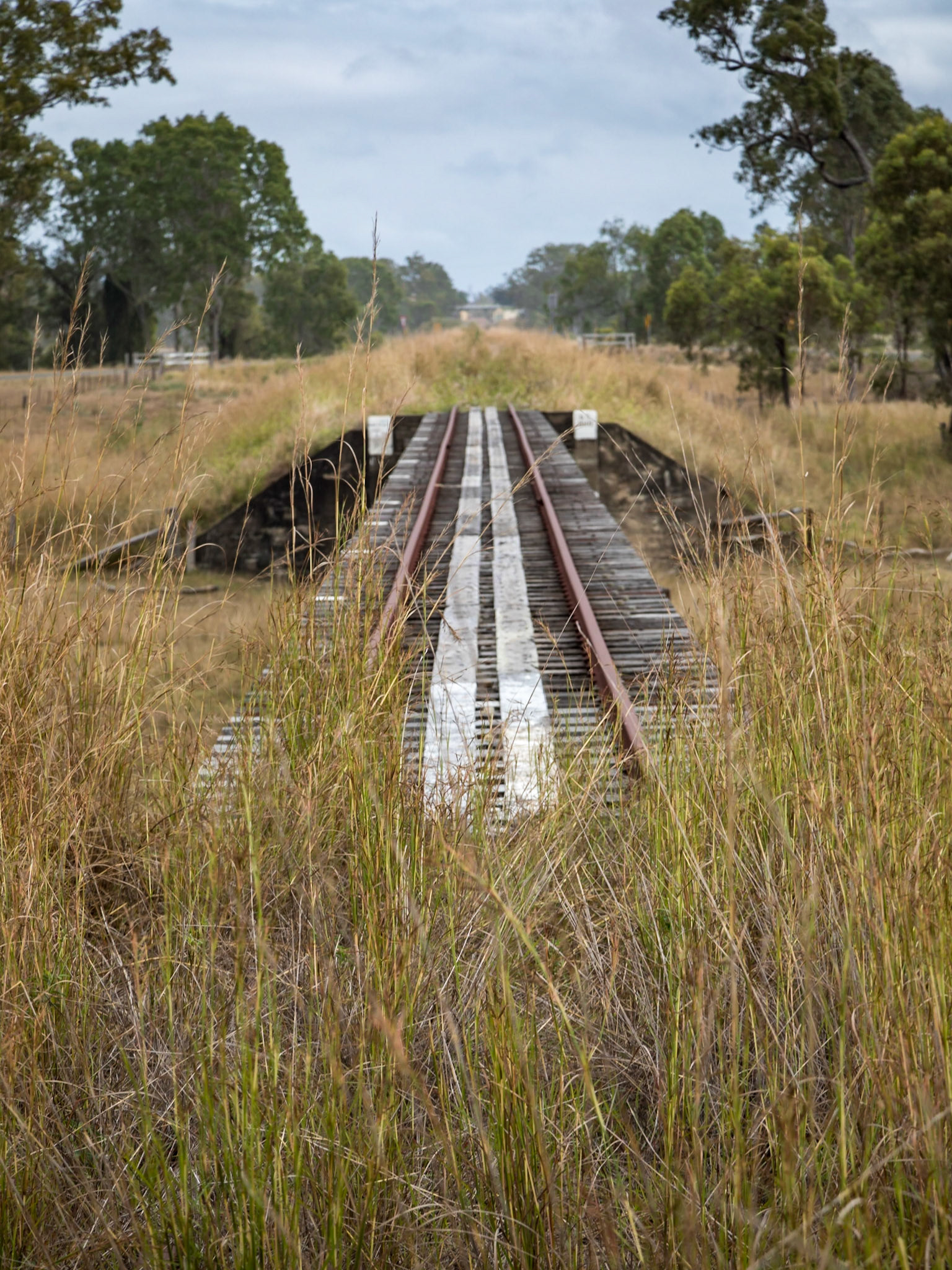 Abandoned railway lines across a wooden bridge