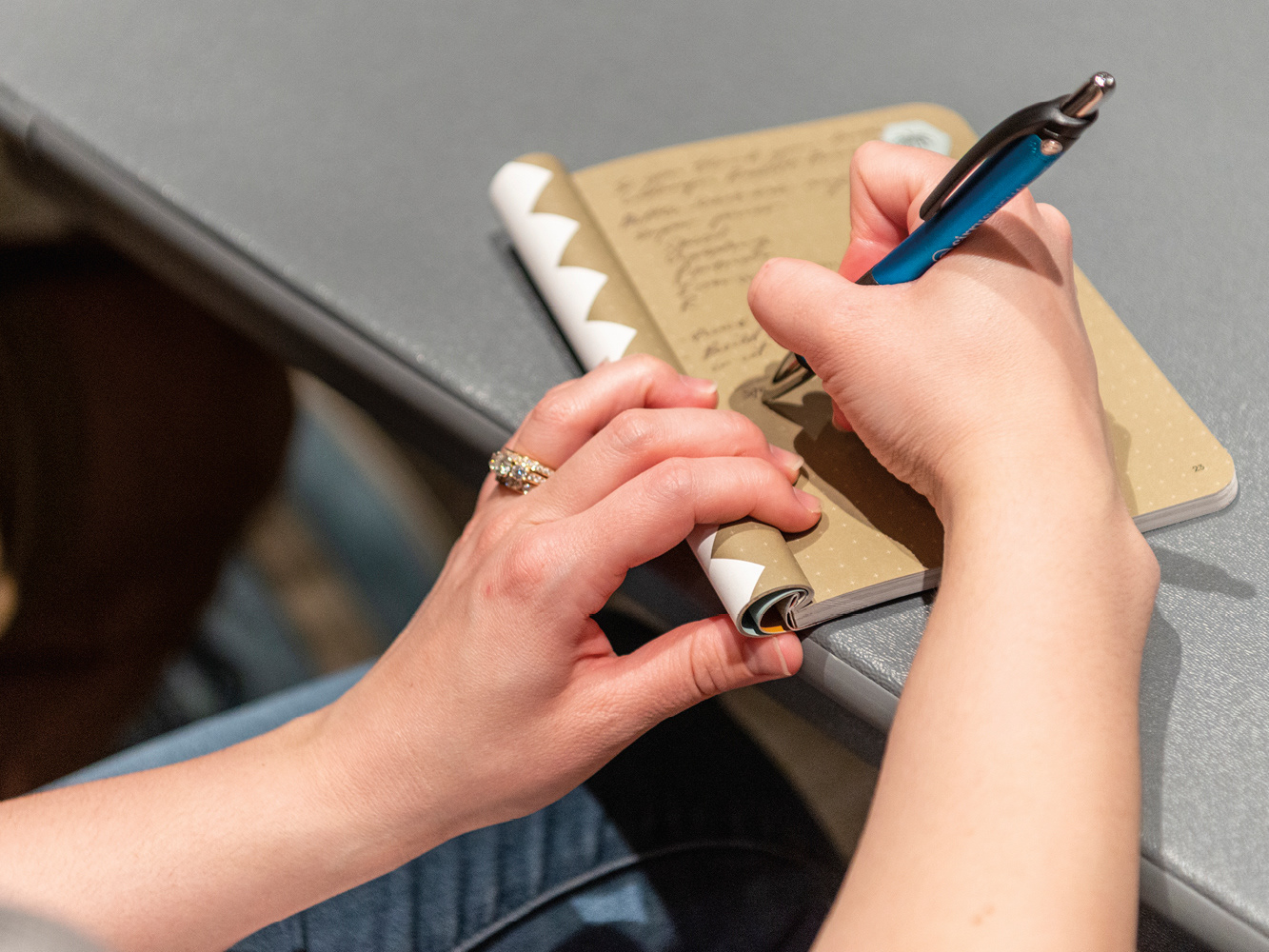 Photo of Phoenix Design Week attendee taking notes in the program book
