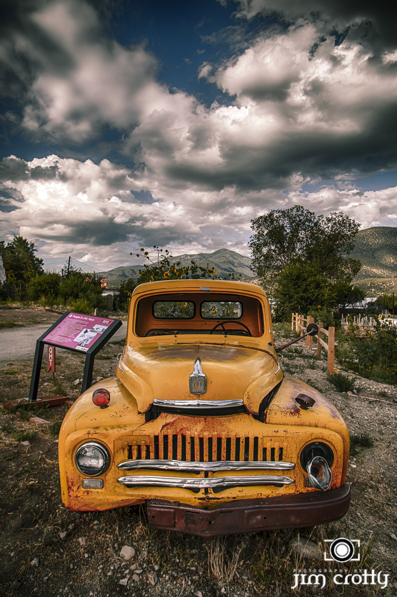 Old cars and landscape in Questa, New Mexico by Jim Crotty