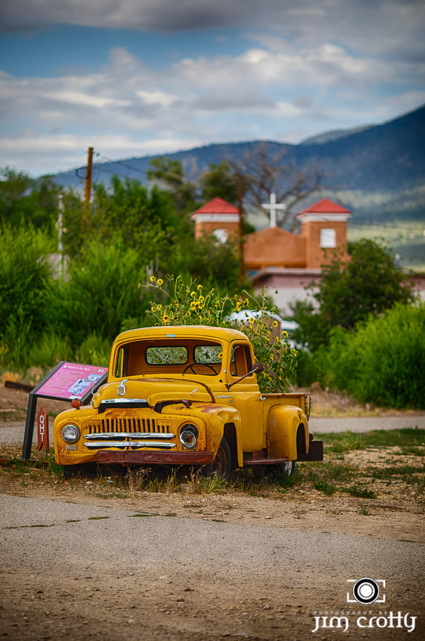 Old cars and landscape in Questa, New Mexico by Jim Crotty