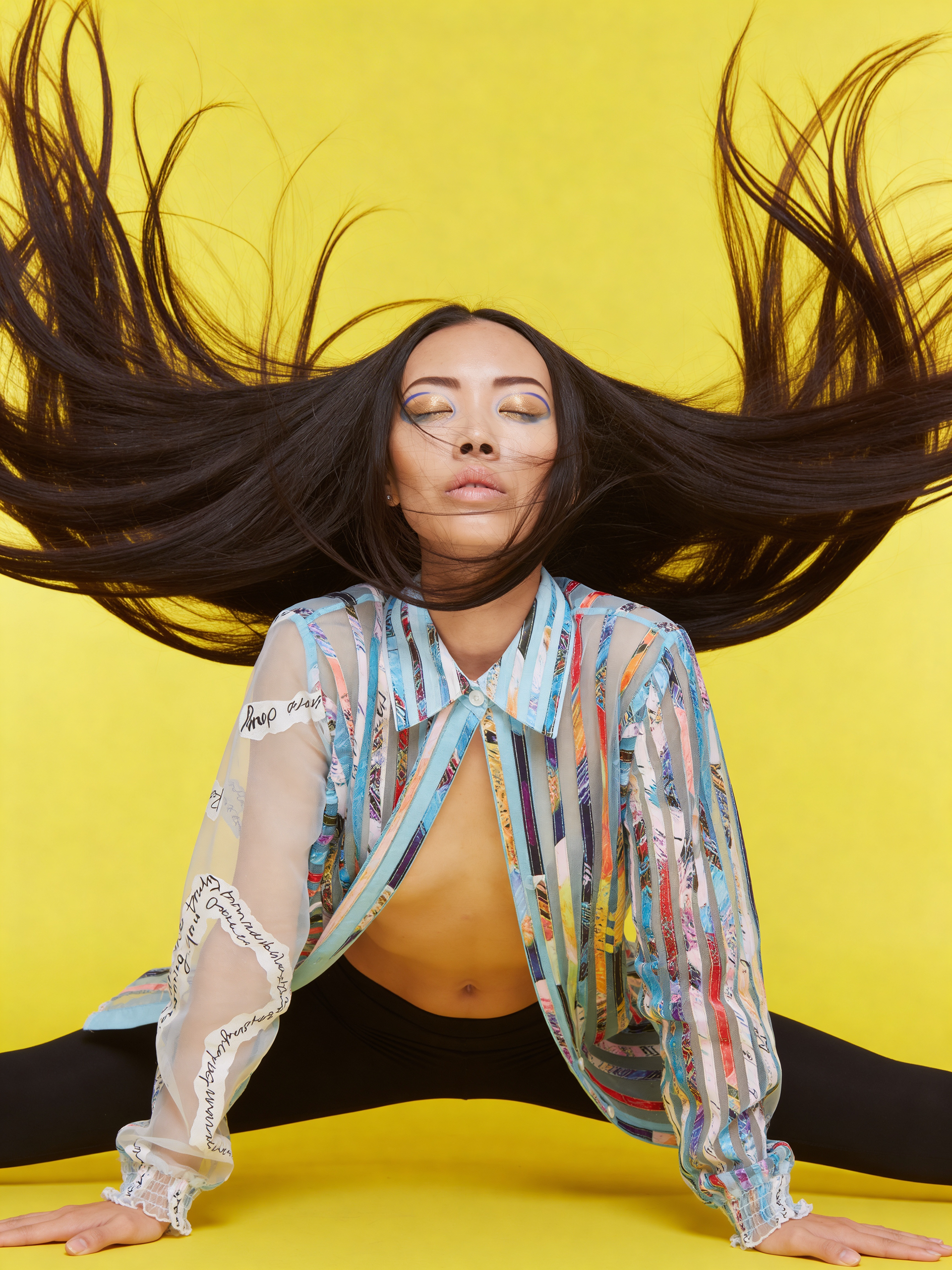 Fashion editorial portrait with yoga-inspired pose emphasizing blouse design.