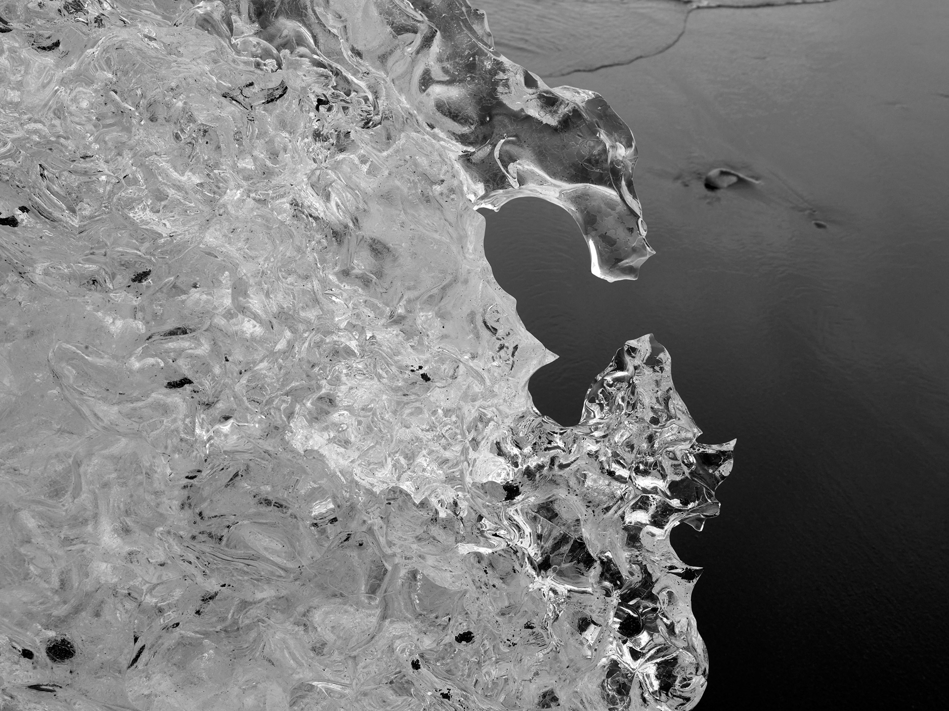 Single iceberg resting on black sand beach in Iceland with ocean in background