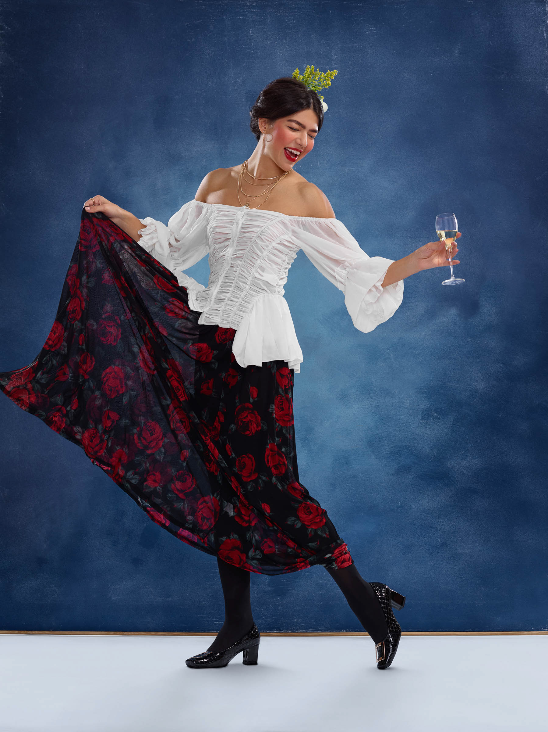 Frida Kahlo inspired portrait of woman dancing with wine glass in studio