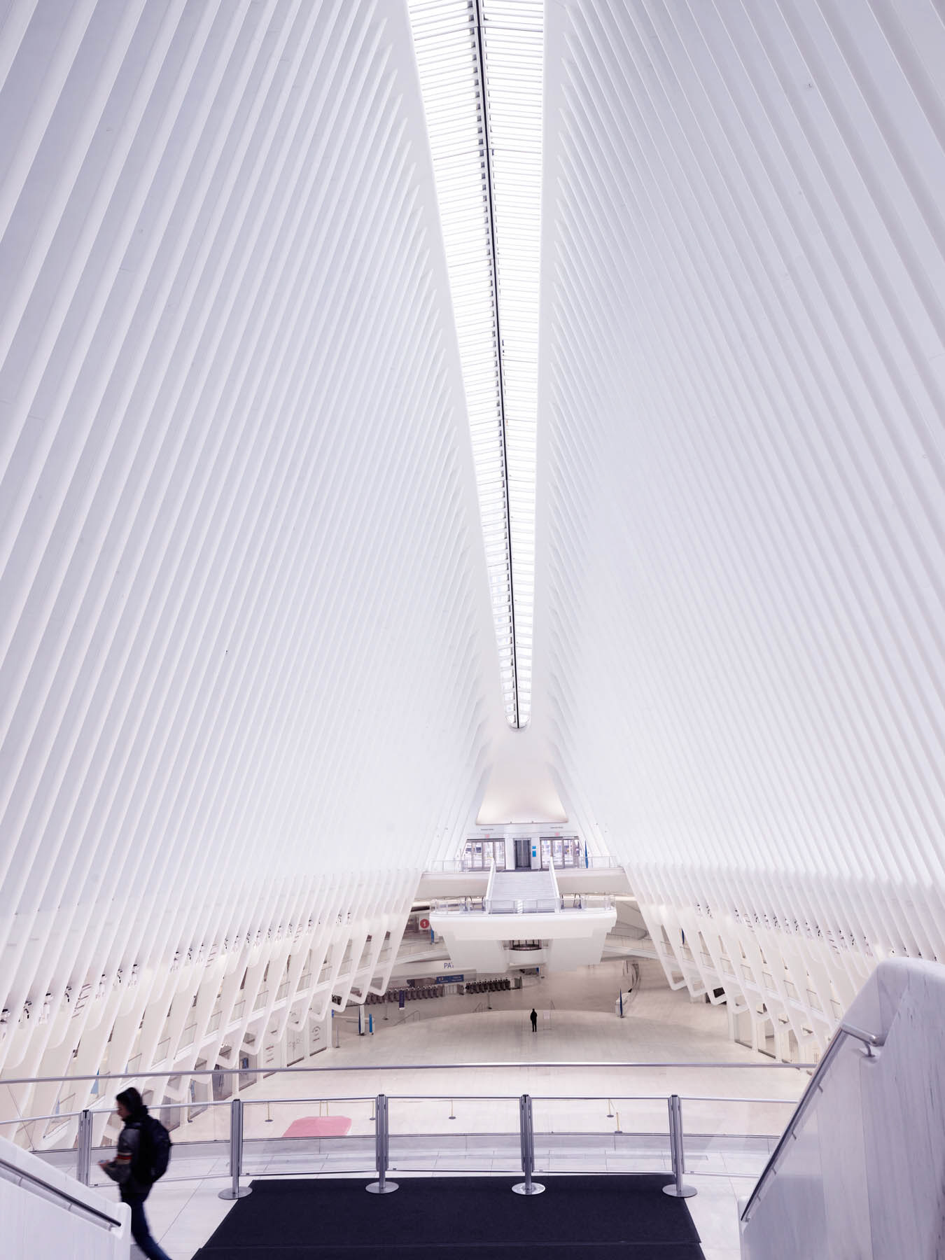 Empty World Trade Center Oculus interior during Covid, photographed from above with the white ribbed architecture and a lone person in the space.