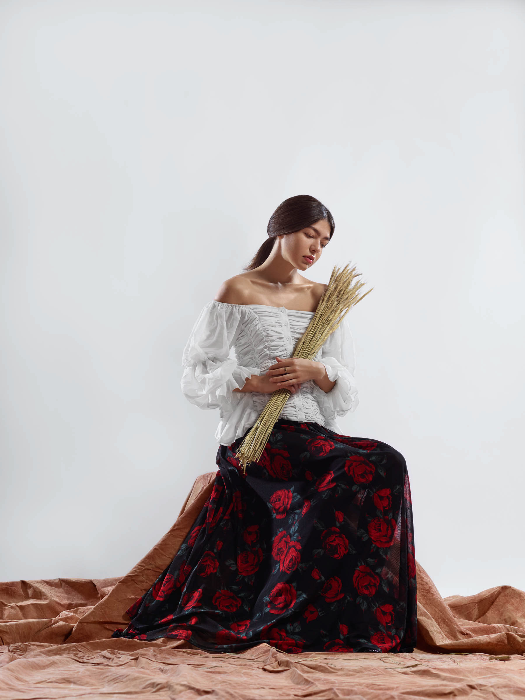 Frida Kahlo inspired portrait of woman seated holding wheat on canvas platform
