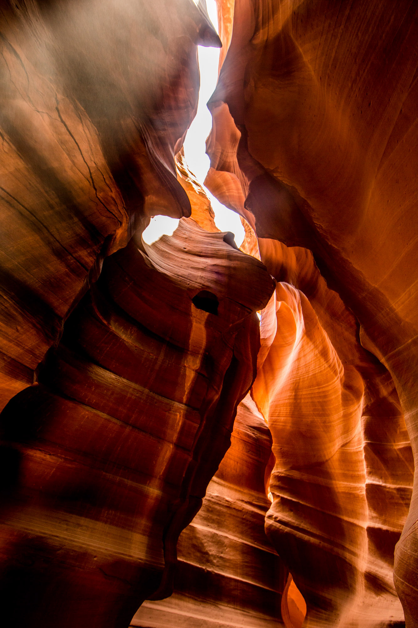 Antelope Canyon interior with sunlight beams and dust particles in red canyon walls