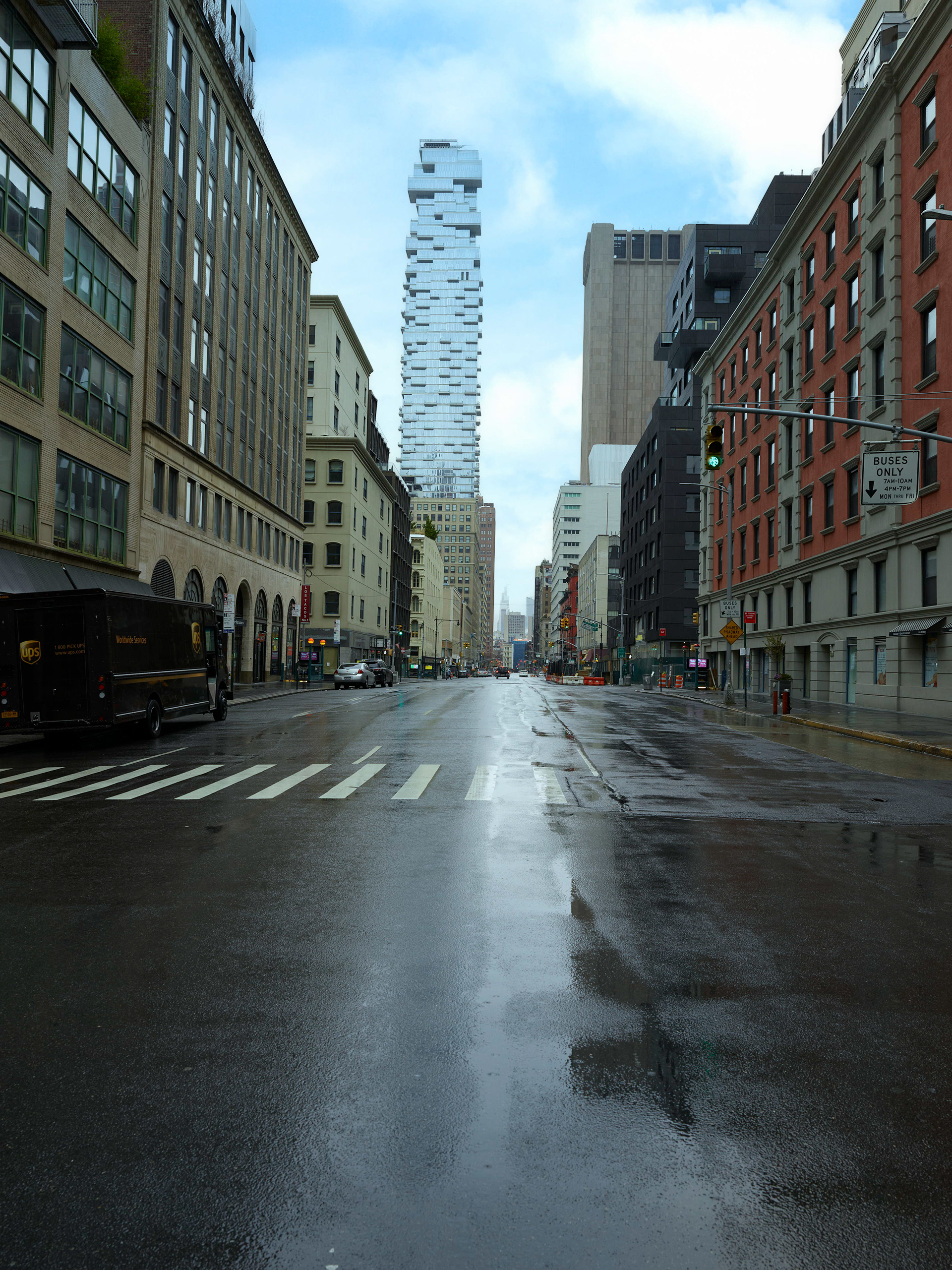 Quiet Financial District street in New York City during Covid, photographed with empty lanes, wet pavement, construction scaffolding, and downtown architecture.