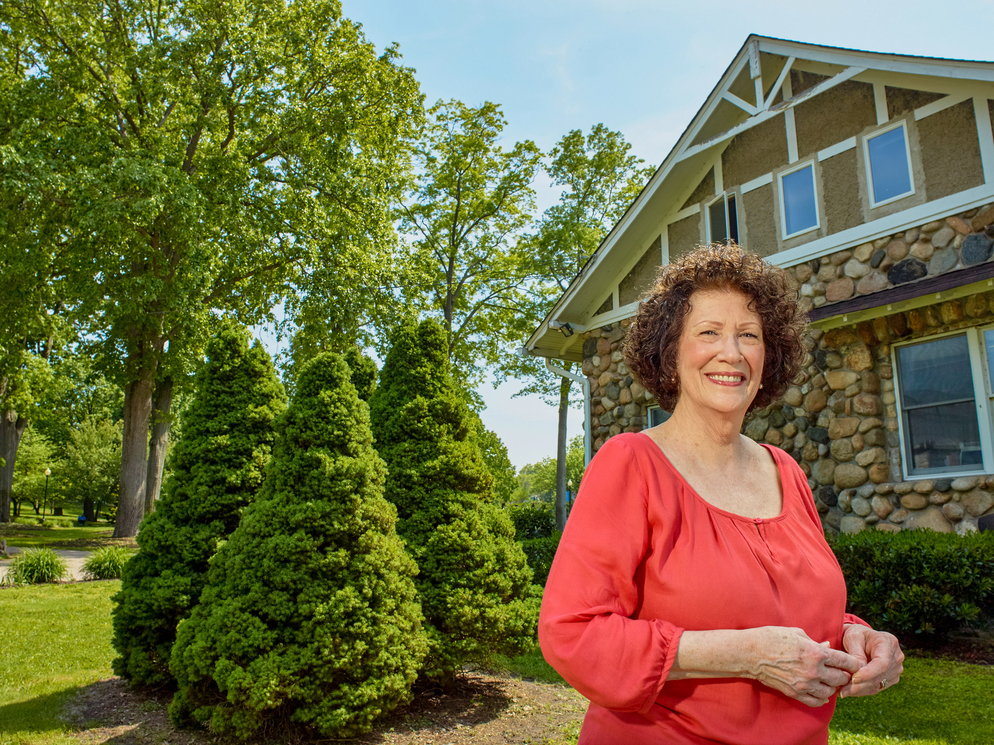 Environmental lifestyle portrait of homeowner standing in front of suburban house photographed for PSEG Long Island advertising campaign produced by Brushfire.