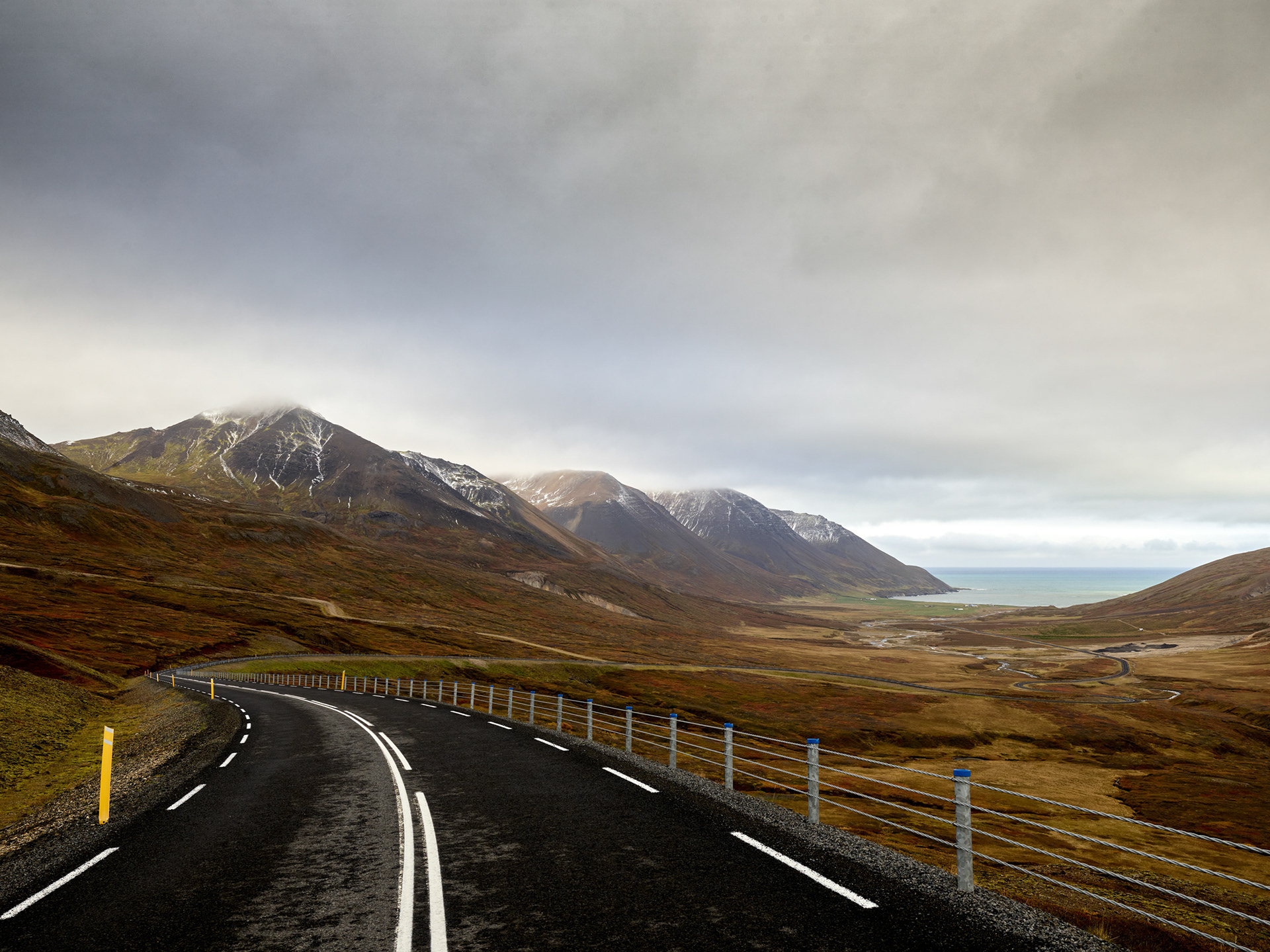 Road leading through Iceland landscape toward Vik with mountains and open sky