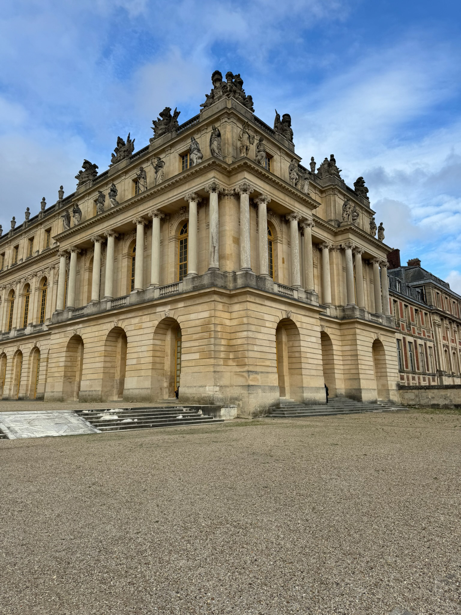Palace of Versailles exterior viewed from garden with symmetrical architecture and no people