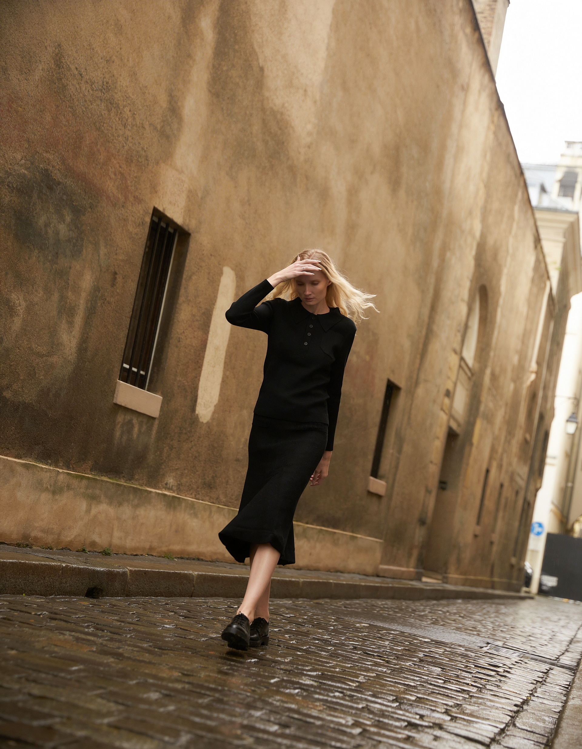 Model walking through Paris alley in modest black outfit cinematic fashion photography