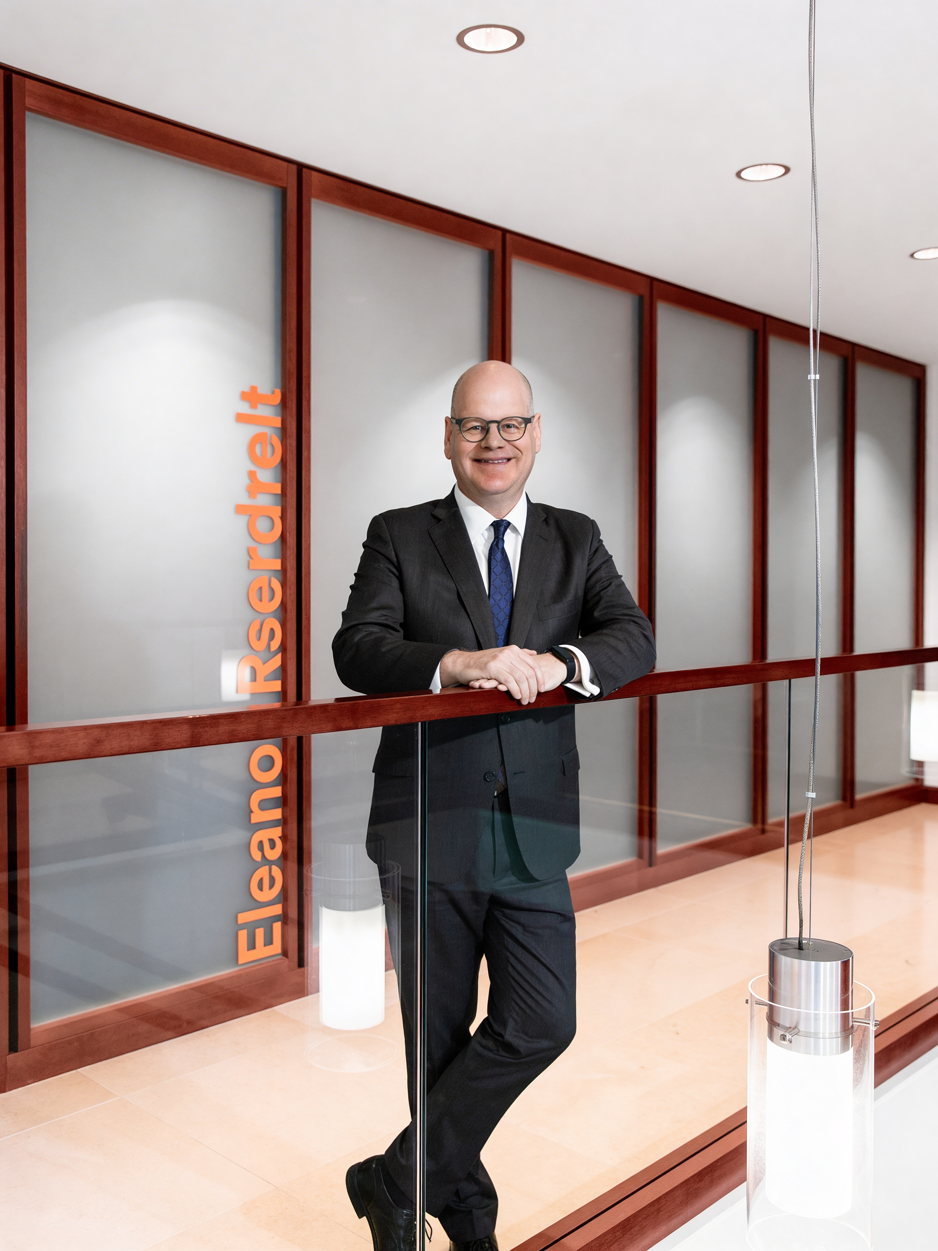 Executive portrait of Keith Mestrich photographed in front of the executive boardroom at Amalgamated Bank headquarters in New York.