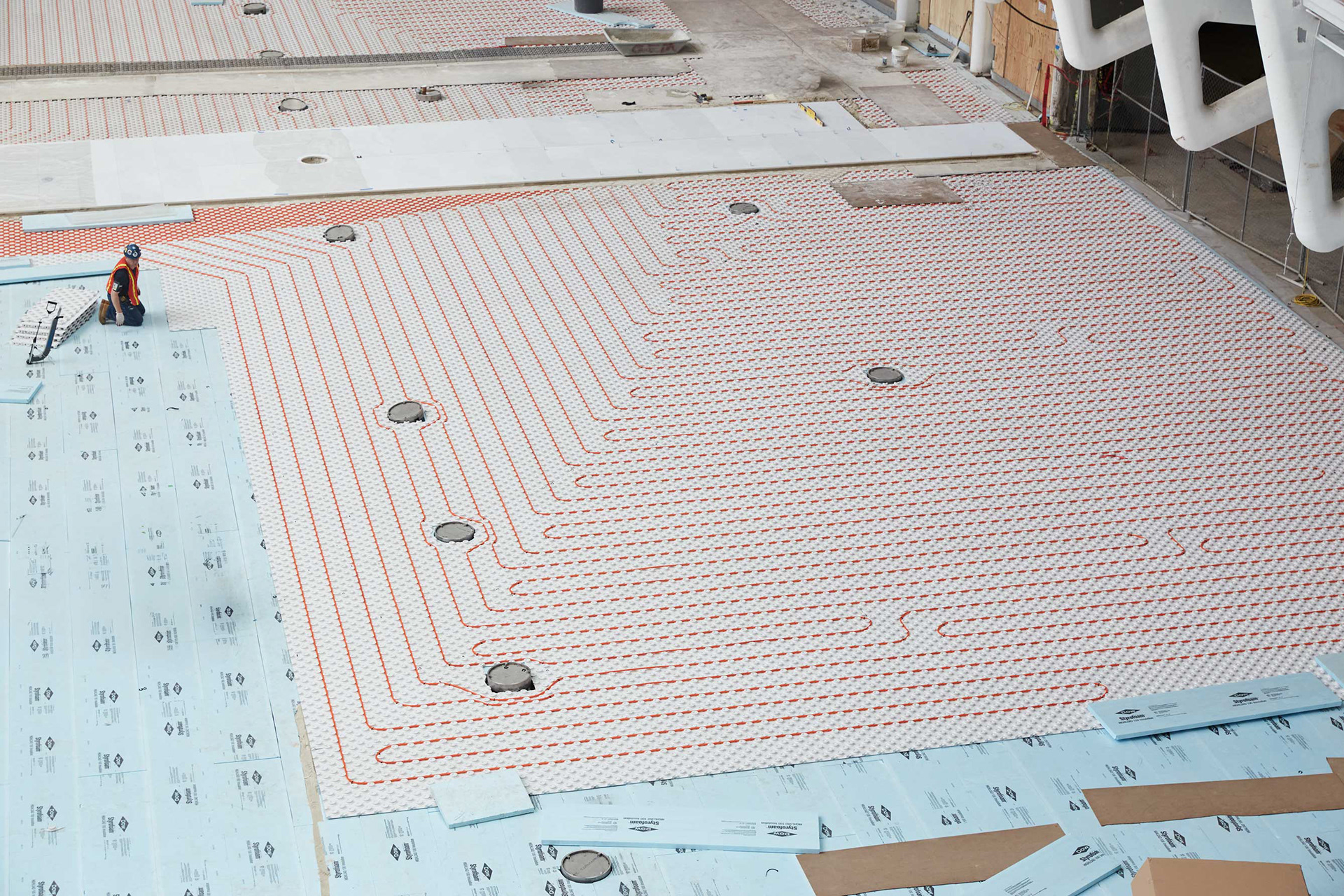 Worker installing radiant heated flooring inside the World Trade Center Oculus during construction in Lower Manhattan.