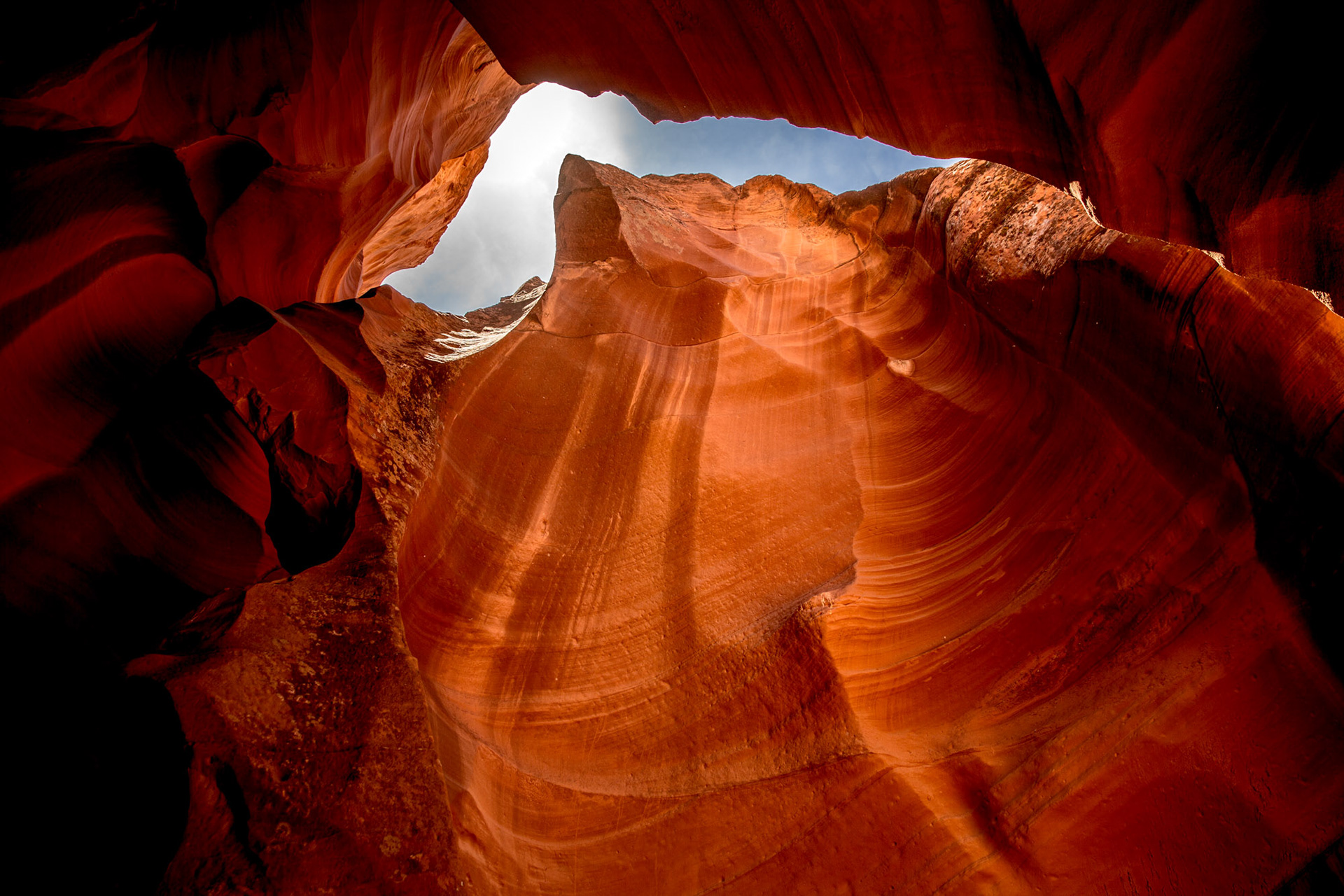 Antelope Canyon narrow opening forming V shape with blue sky visible above