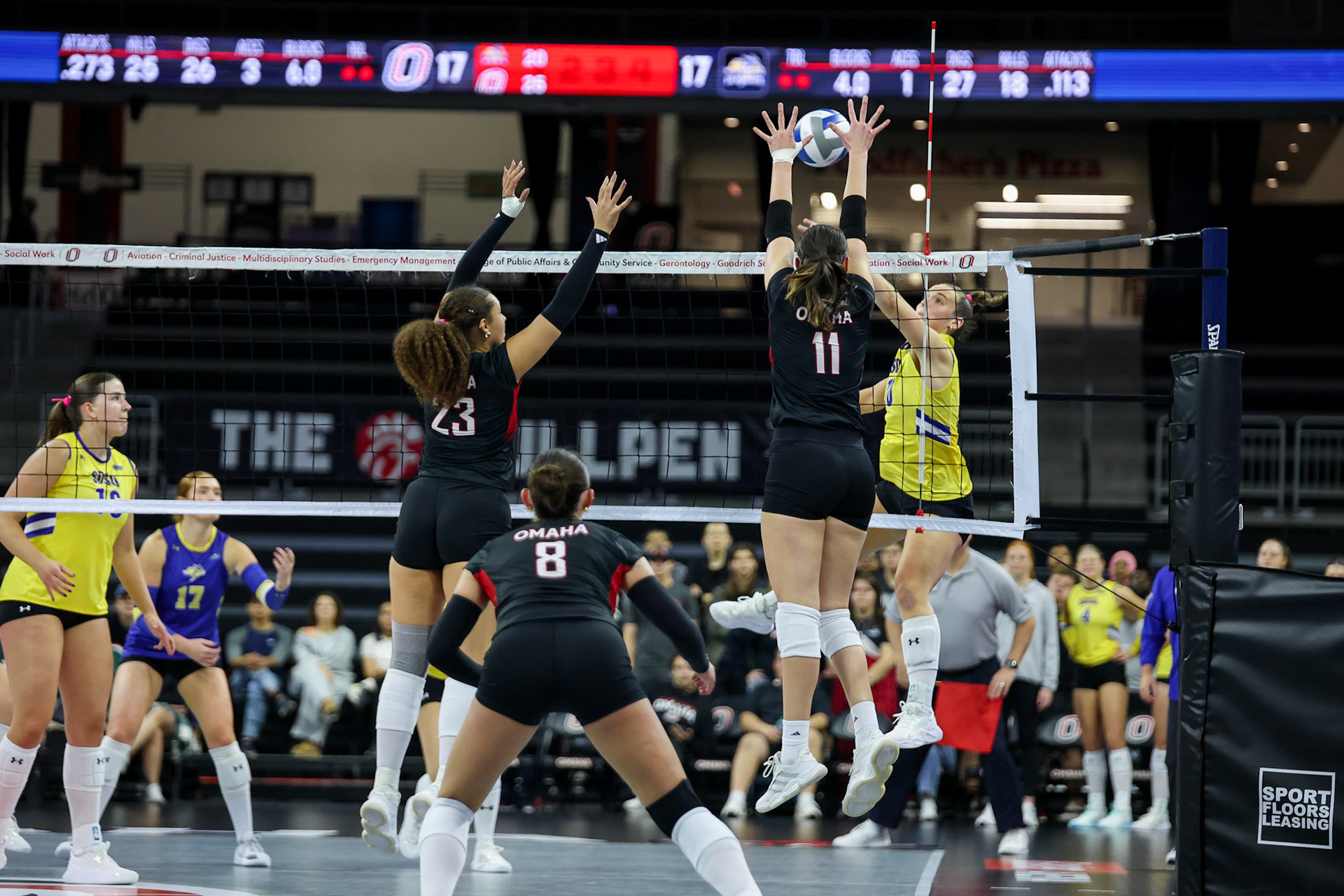Omaha Mavericks Lara Marić (11) and Alizabeth Jacobsen (23) attempt to block an attack during a college volleyball match against the South Dakota State Jackrabbits on Thursday, Oct. 1, 2026, at Baxter Arena in Omaha, Neb. Photo by Abdoul Sow.