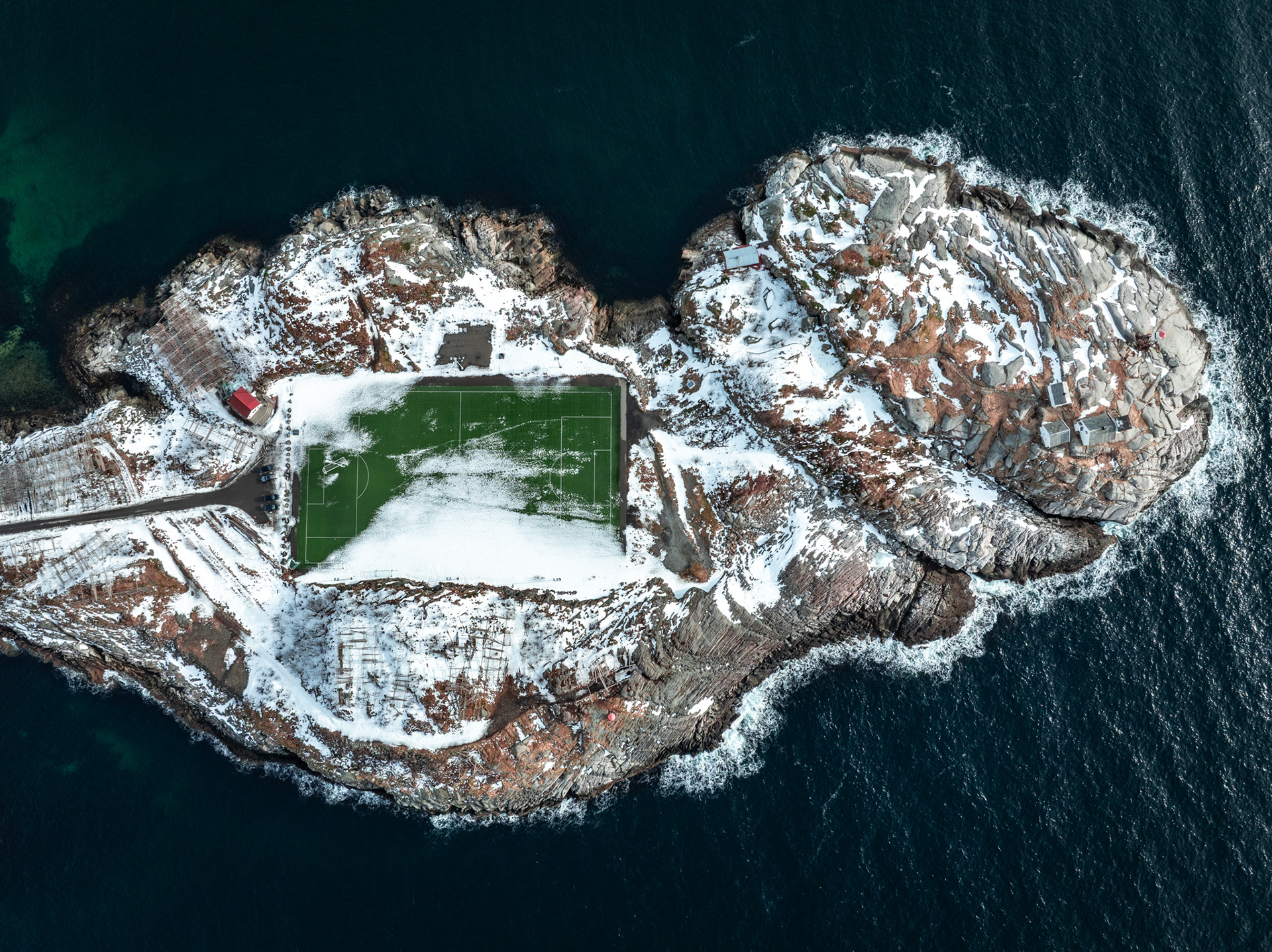 Sports field almost entirely hidden underneath the snow. At the top left of the little island you can see the hanging racks where they dry hang Cod fish.