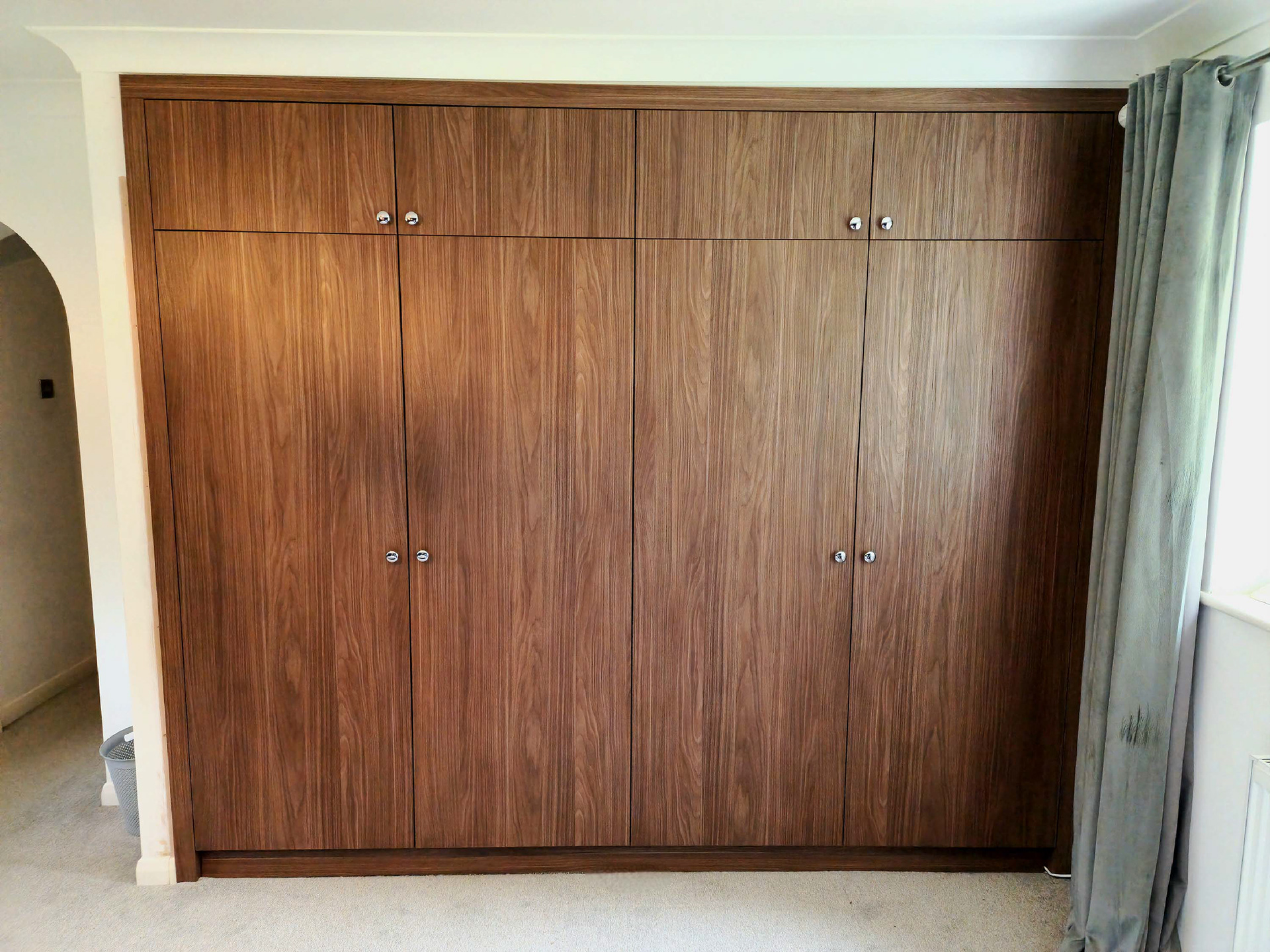 Master bedroom custom fitted wardrobes in Lincoln Walnut. Featuring LED rails and soft close Blum hardware.