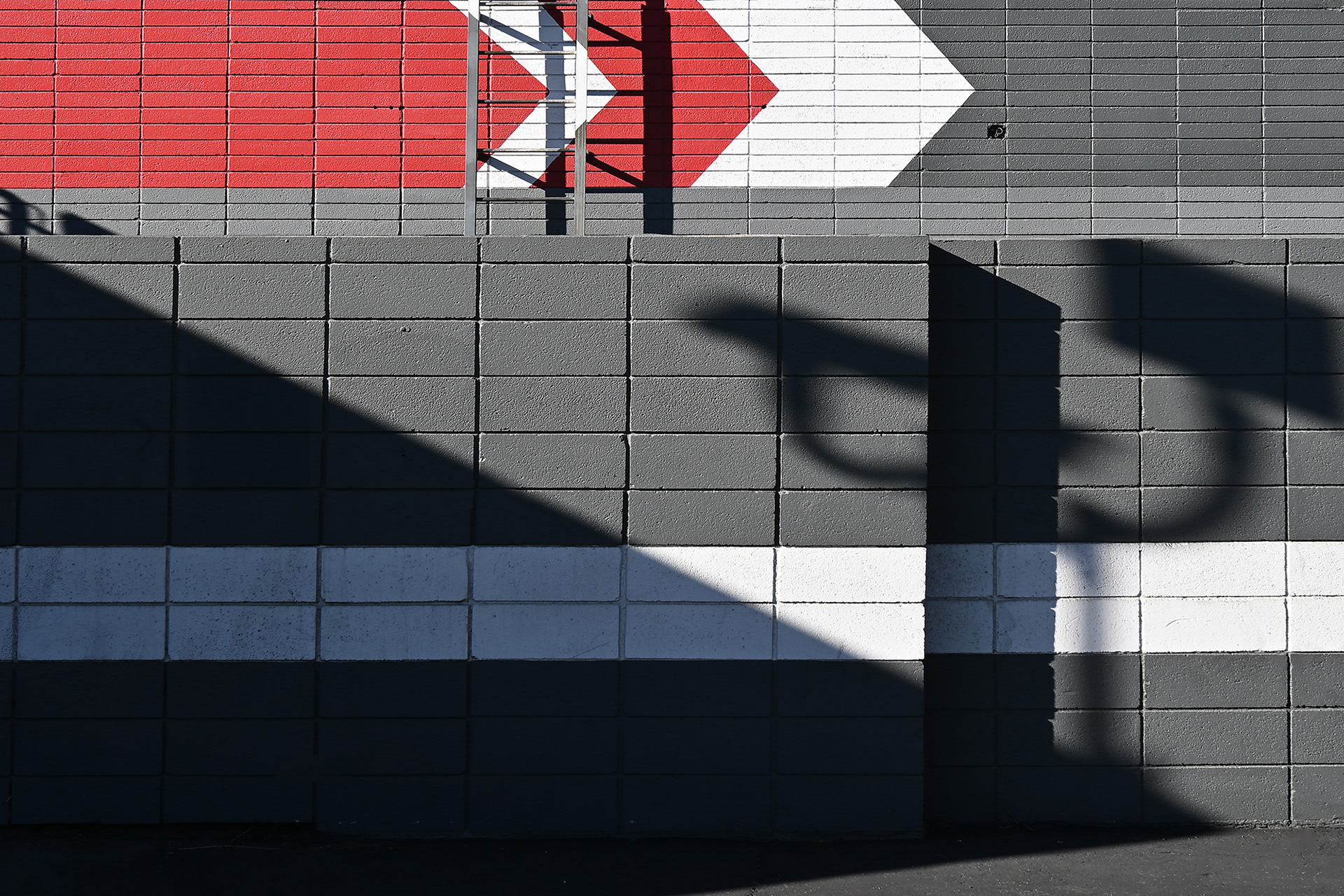 Shadows on a black wall with arrow graphics in red and white