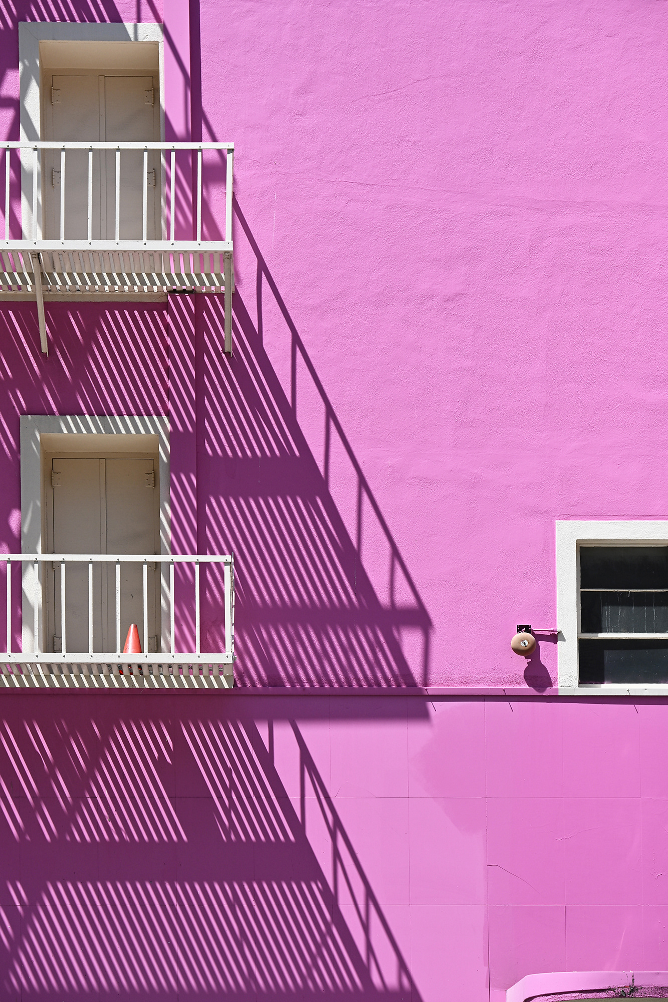 Shadows of a fire escape on the pink walls of Fallas Paredes, downtown, Los Angeles