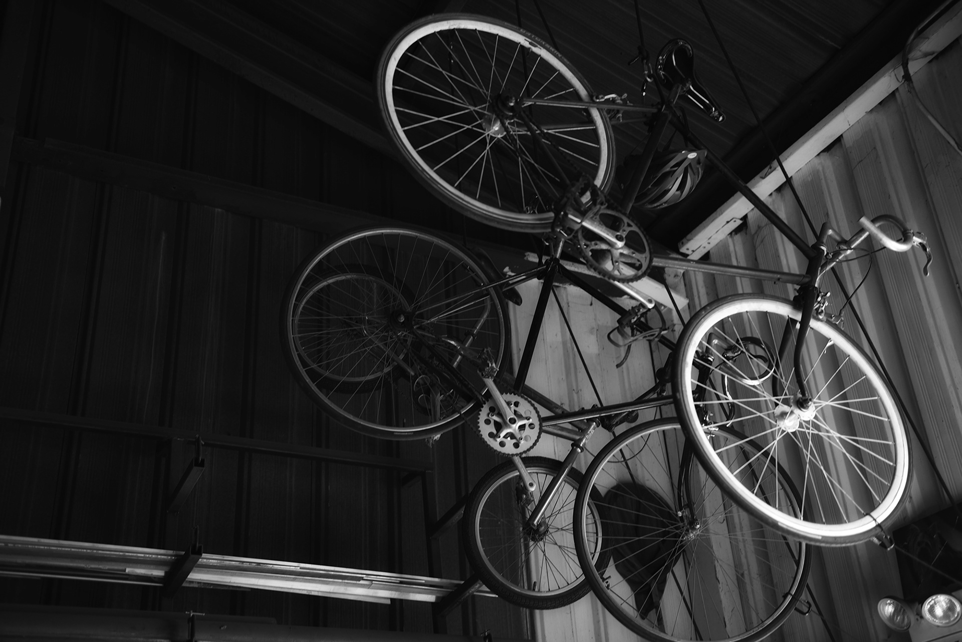 Three Bicycles hanging from the ceiling of a machine shop, black and white photograph