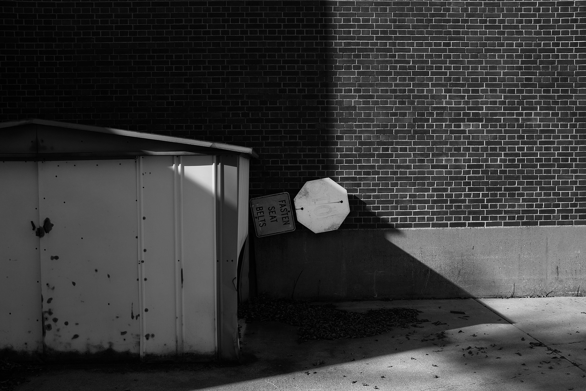 Fasten Seat Belts sign behind dumpster, Ada Minnesota, black and white photograph