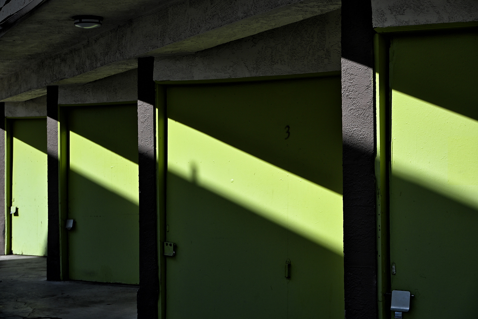 Apartment Building Garages With shafts of light highlighting the green garage doors.